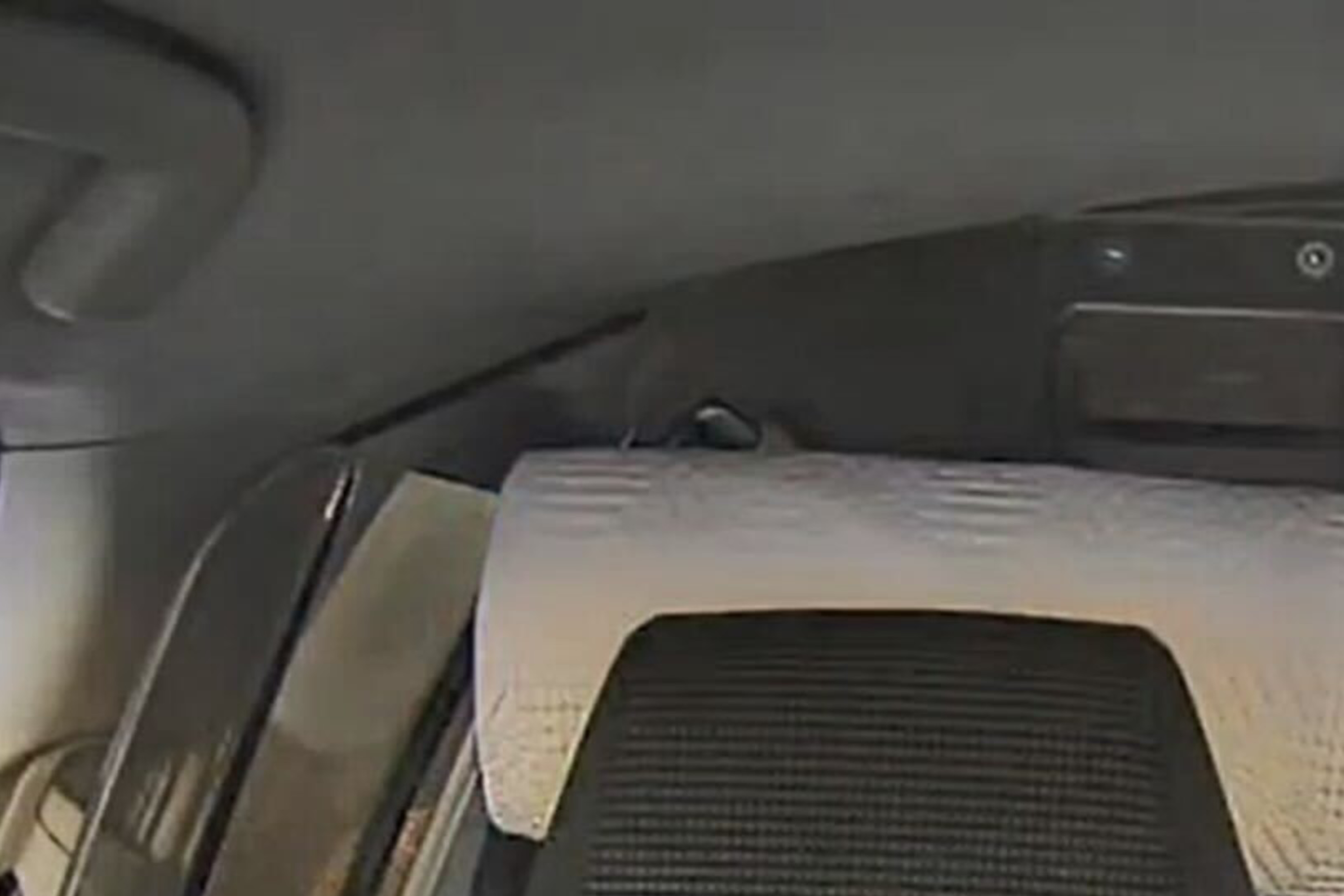 A masked individual in dark clothing is seen in the backseat of a vehicle with a divider. The NYPD Crimestoppers contact info is displayed at the top.