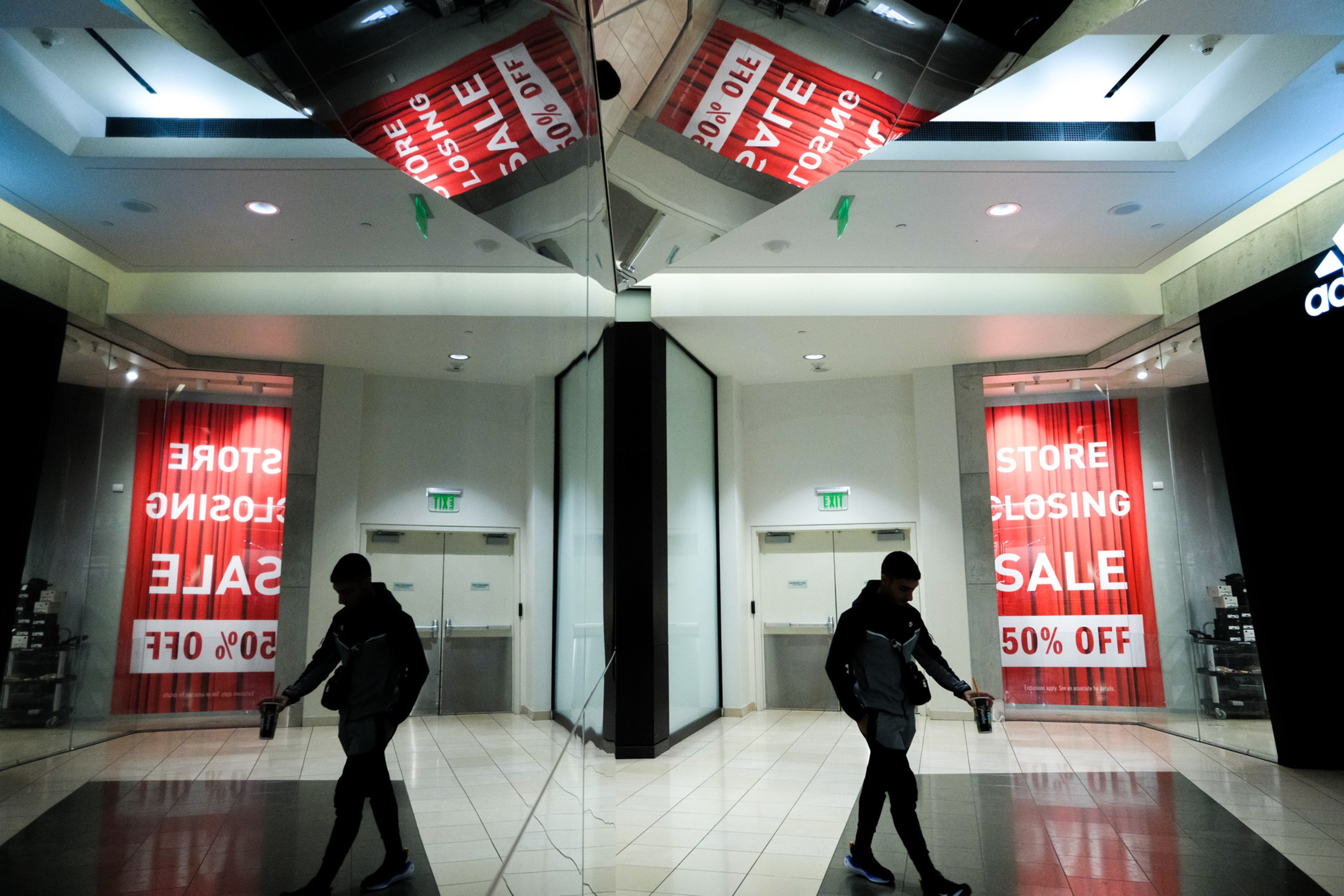 silhouette of a man walking in empty mall