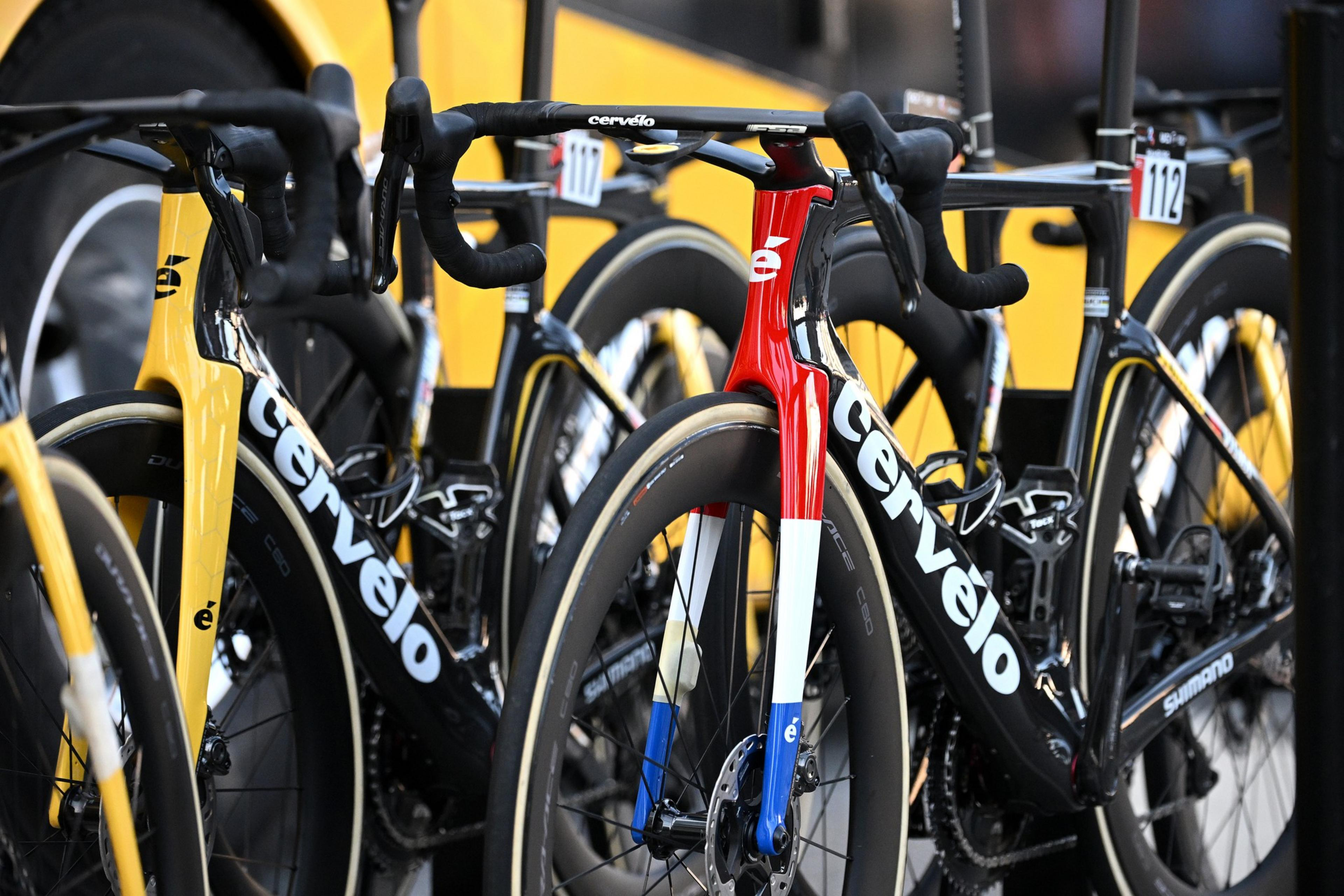 A lineup of yellow and one red-and-white CervÃ©lo road bikes with Shimano parts, mounted on a vehicle rack.