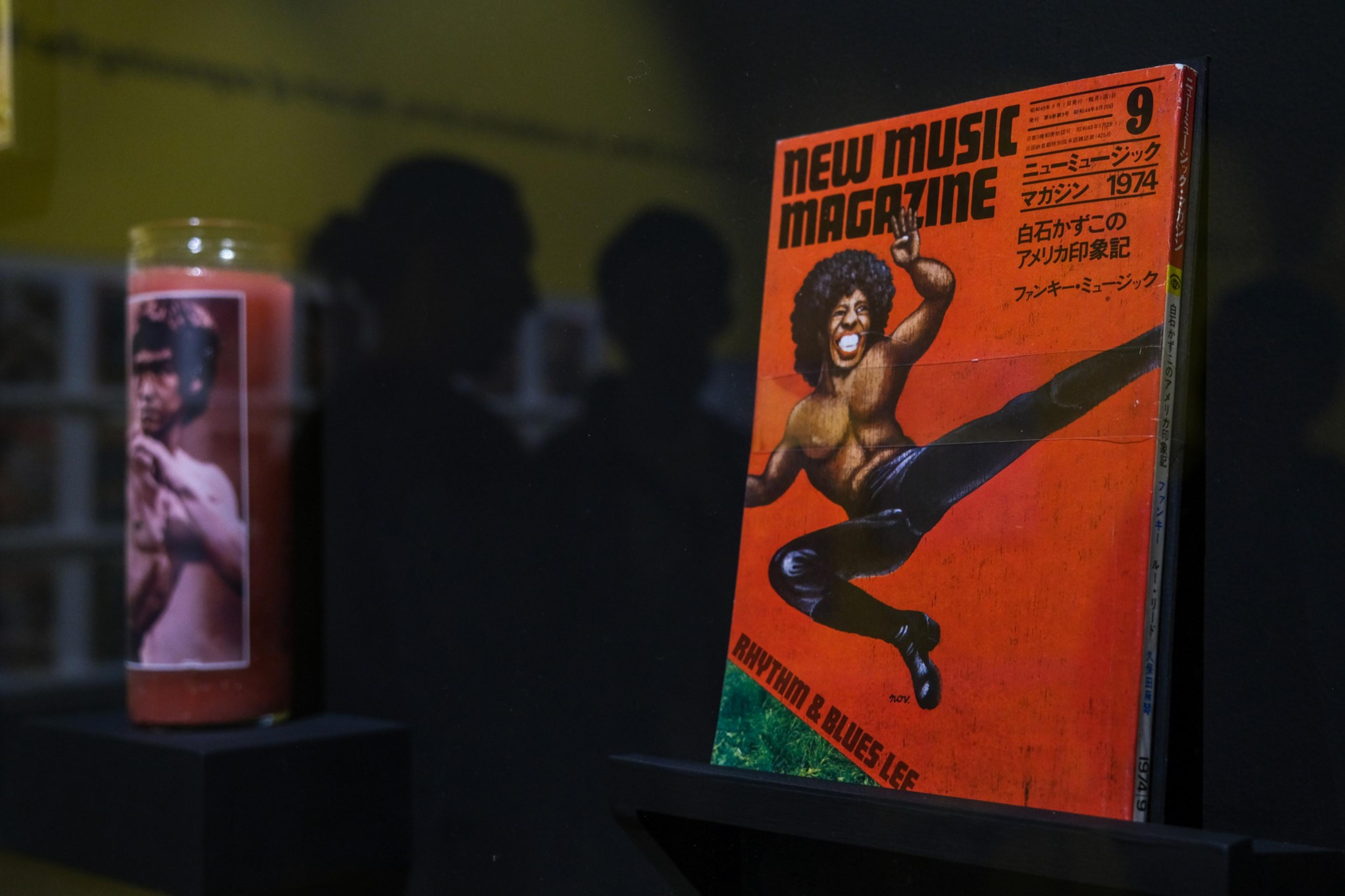 A vintage 1974 issue of New Music Magazine features a dynamic illustration of a man with an afro performing a high kick on its bright orange cover.