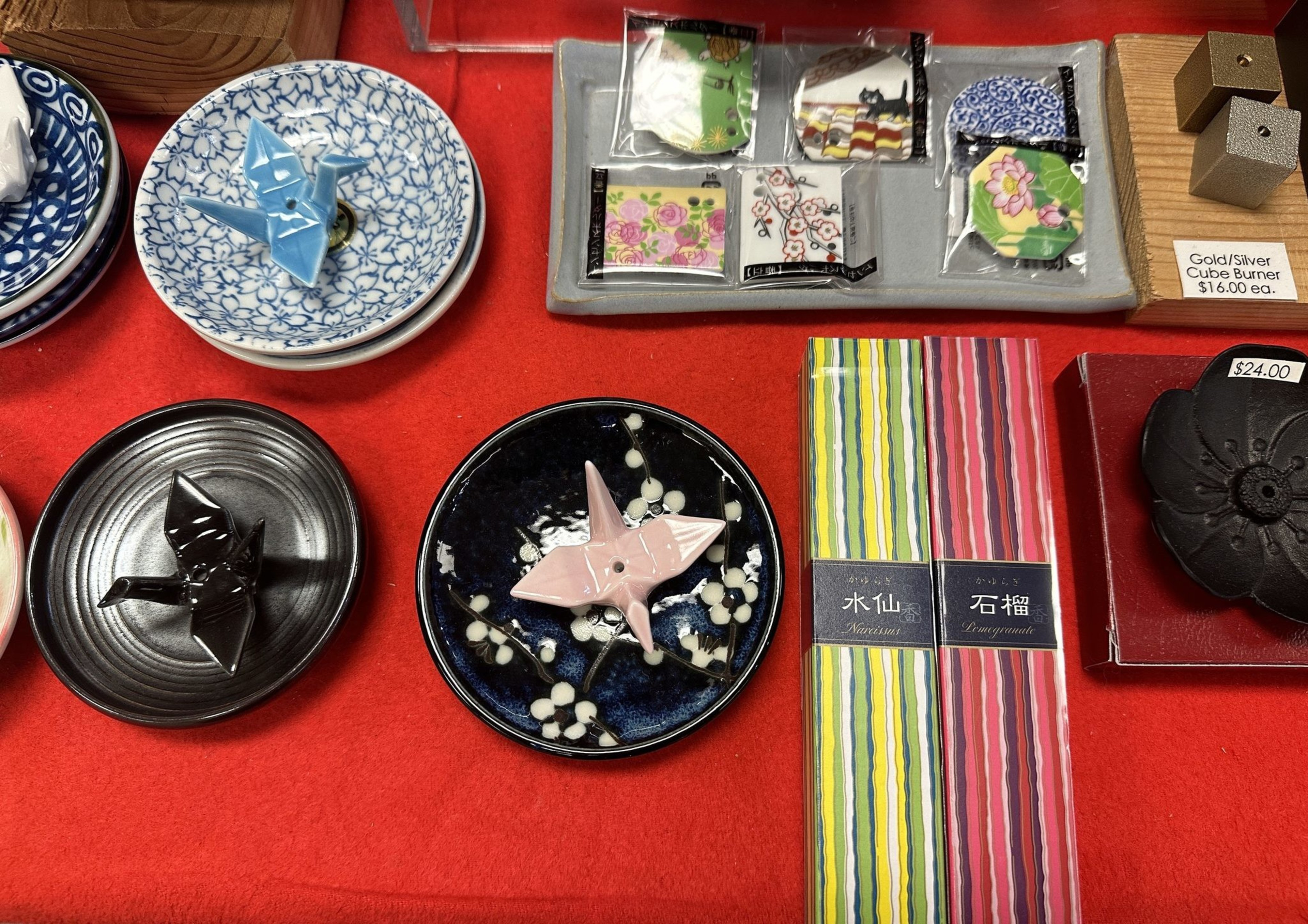 Small incense dishes and holders in the shape of paper cranes lie on display on a red table cloth in a shop in San Francisco's Japantown. 