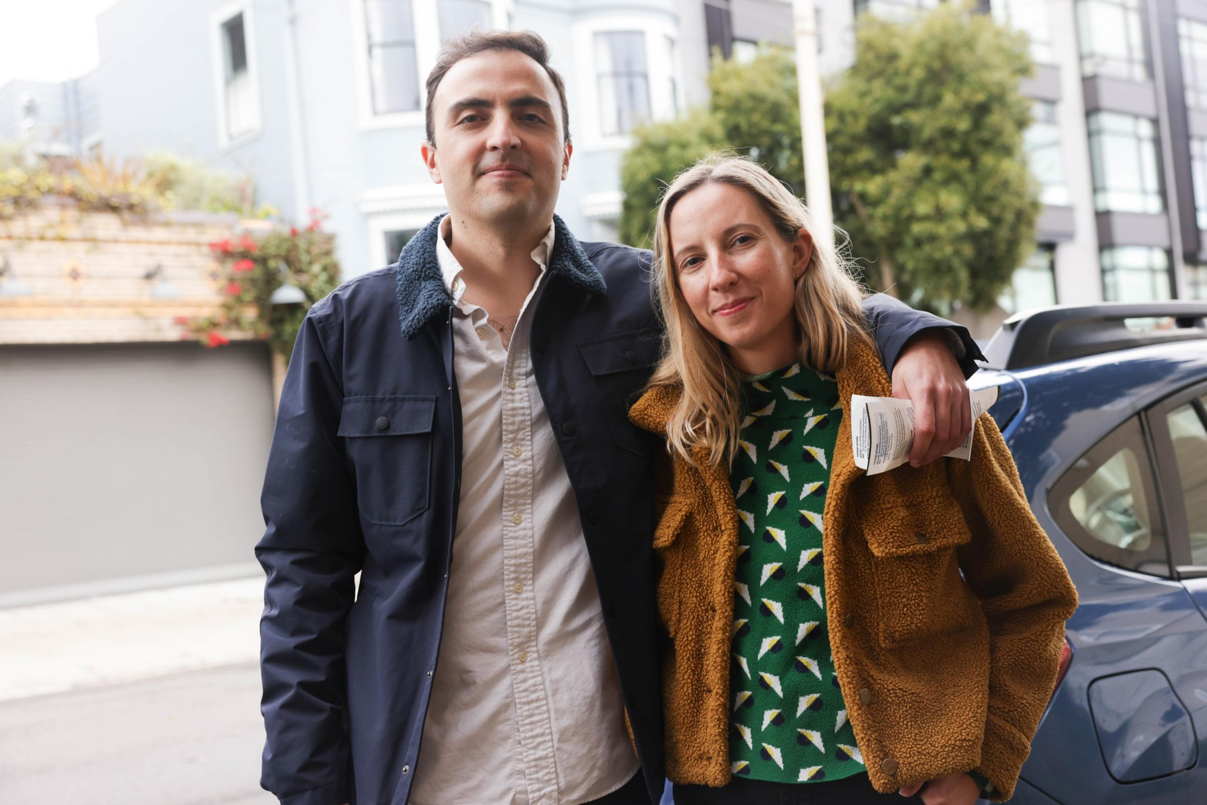 A man and a woman pose with their arms around each other for a photo.