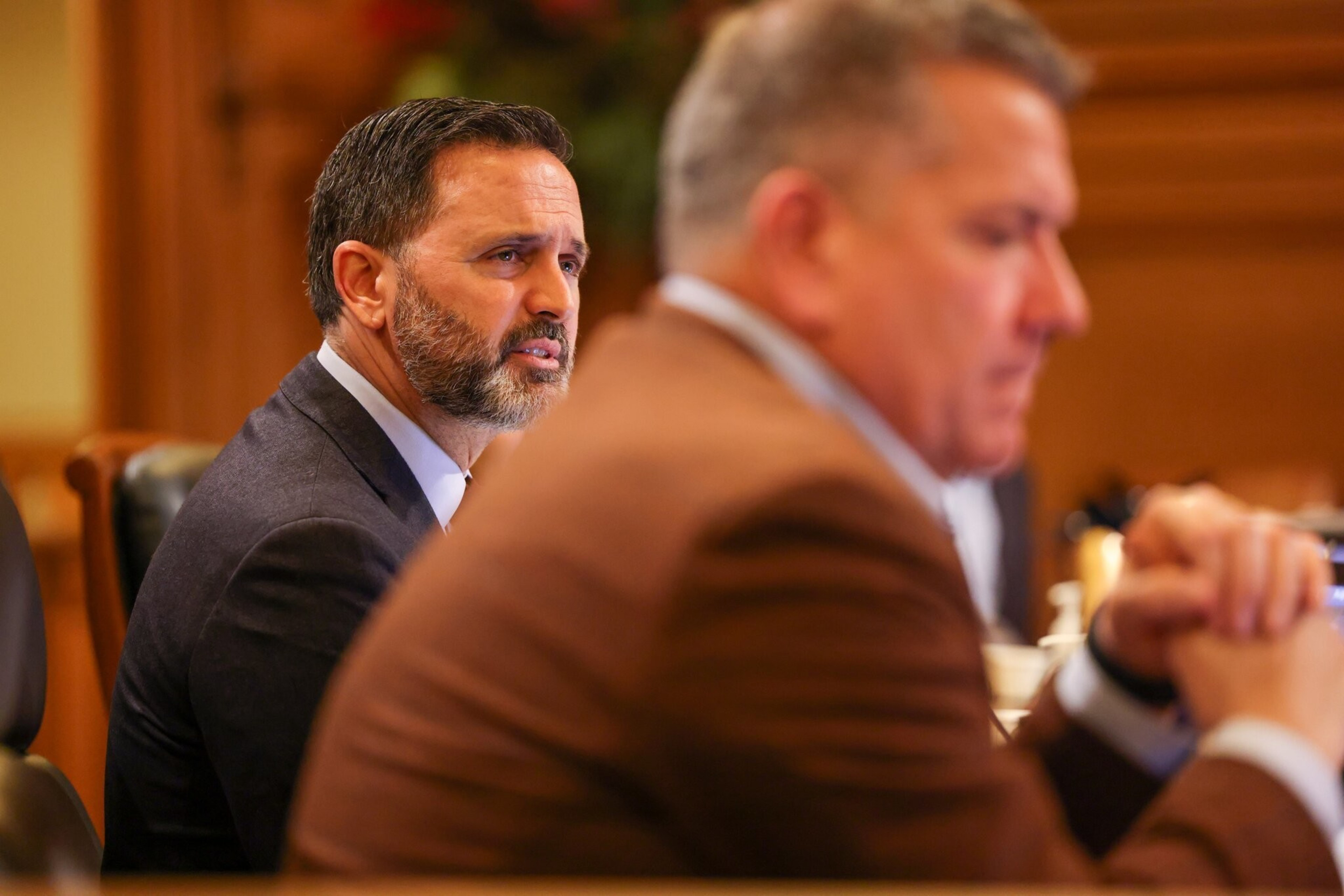 San Francisco Supervisor Ahsha Safai speaks at a City Hall hearing in January 2023 as Supervisor Matt Dorsey listens in the foreground.