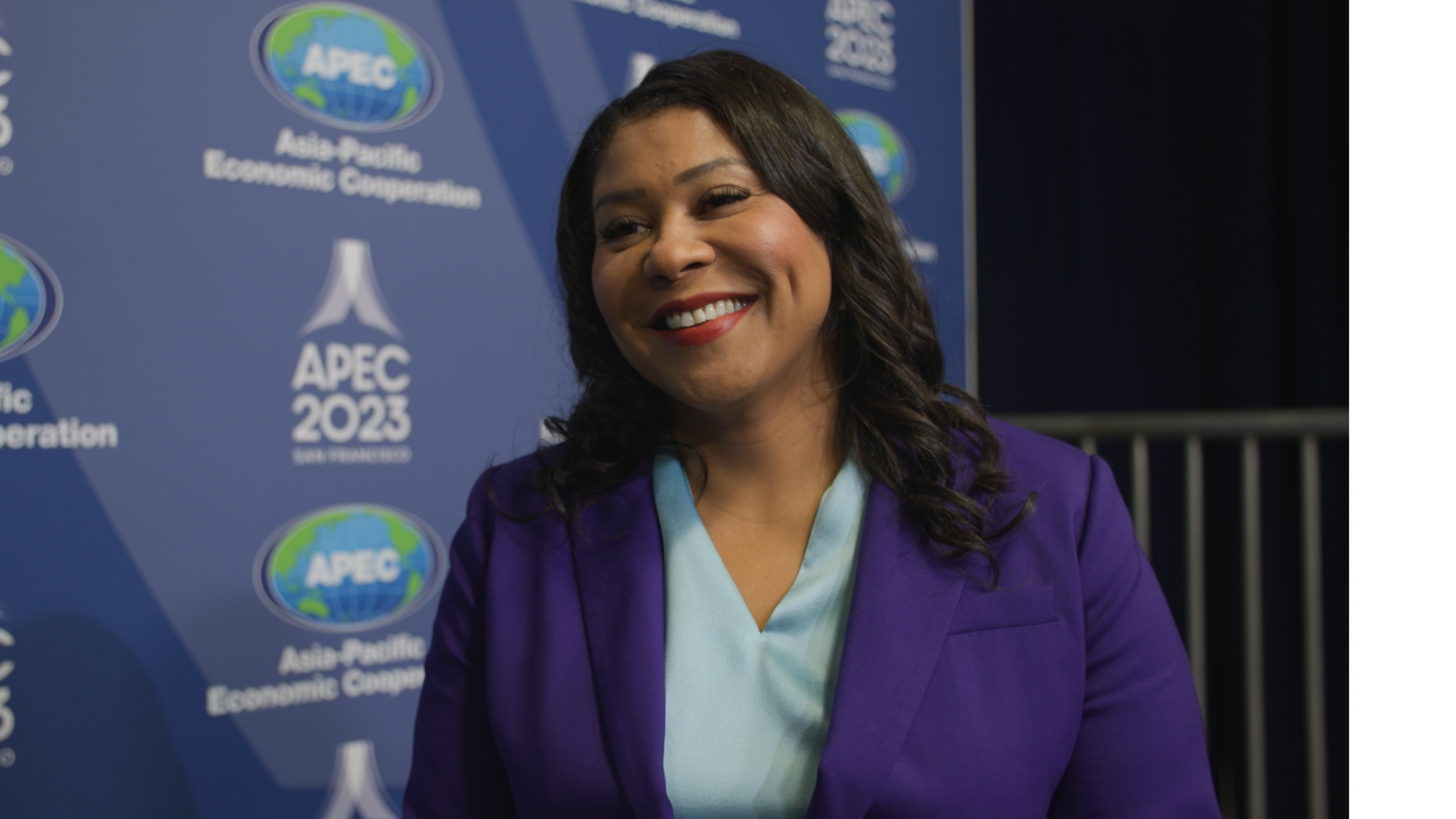 Mayor London Breed smiles during an interview at the APEC summit in San Francisco.