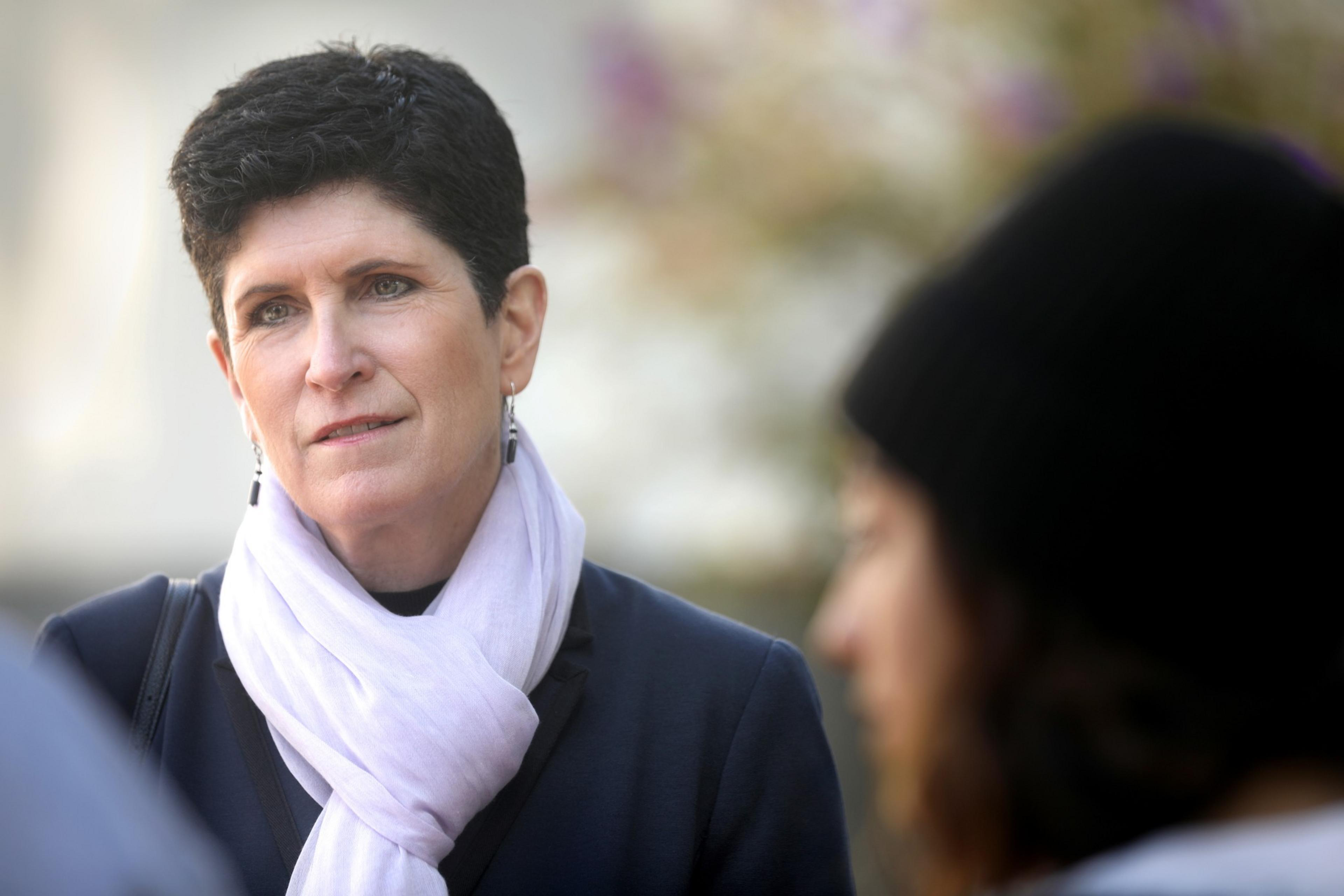 Lynn Mahoney stands outside with a woman in the foreground.