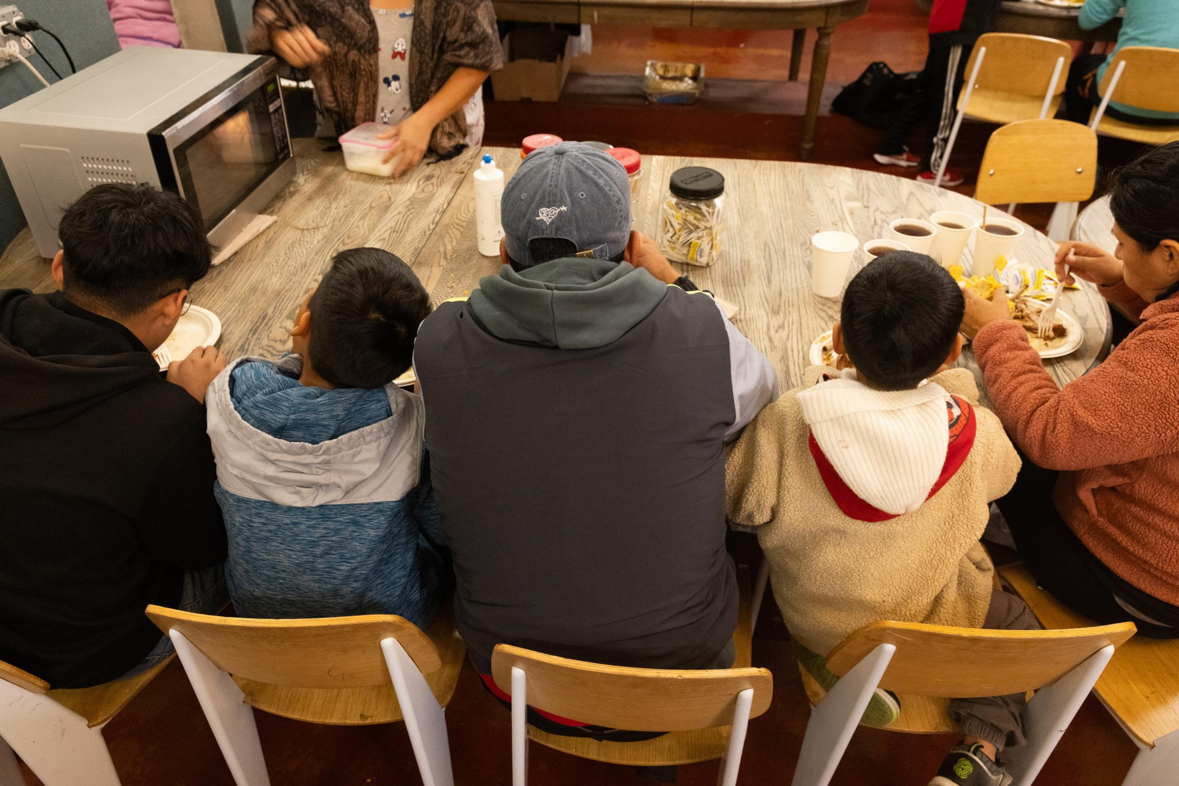A family sits at a table eating a meal.
