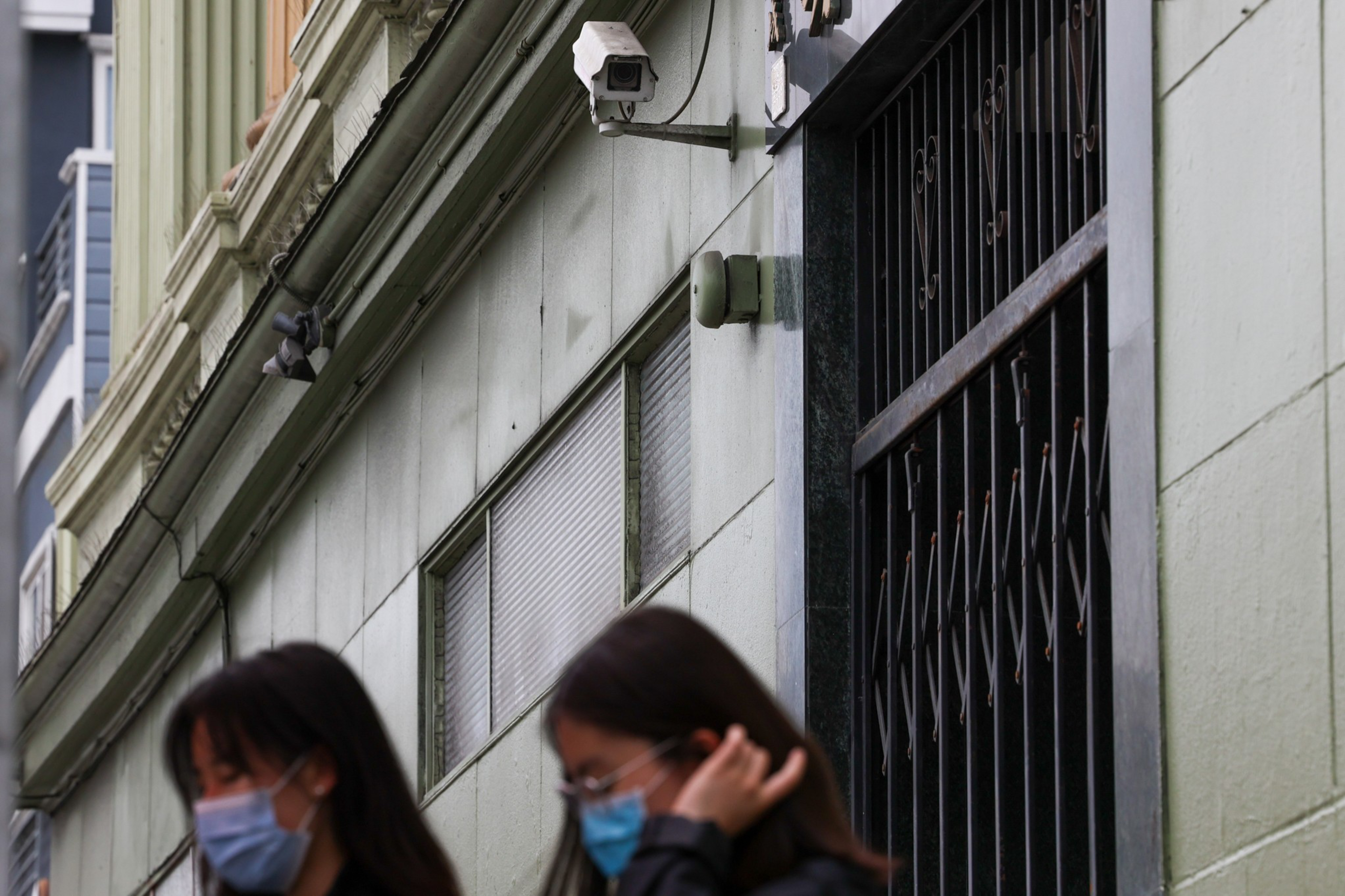 Cameras overlook pedestrians walking on the street in the Inner Sunset.
