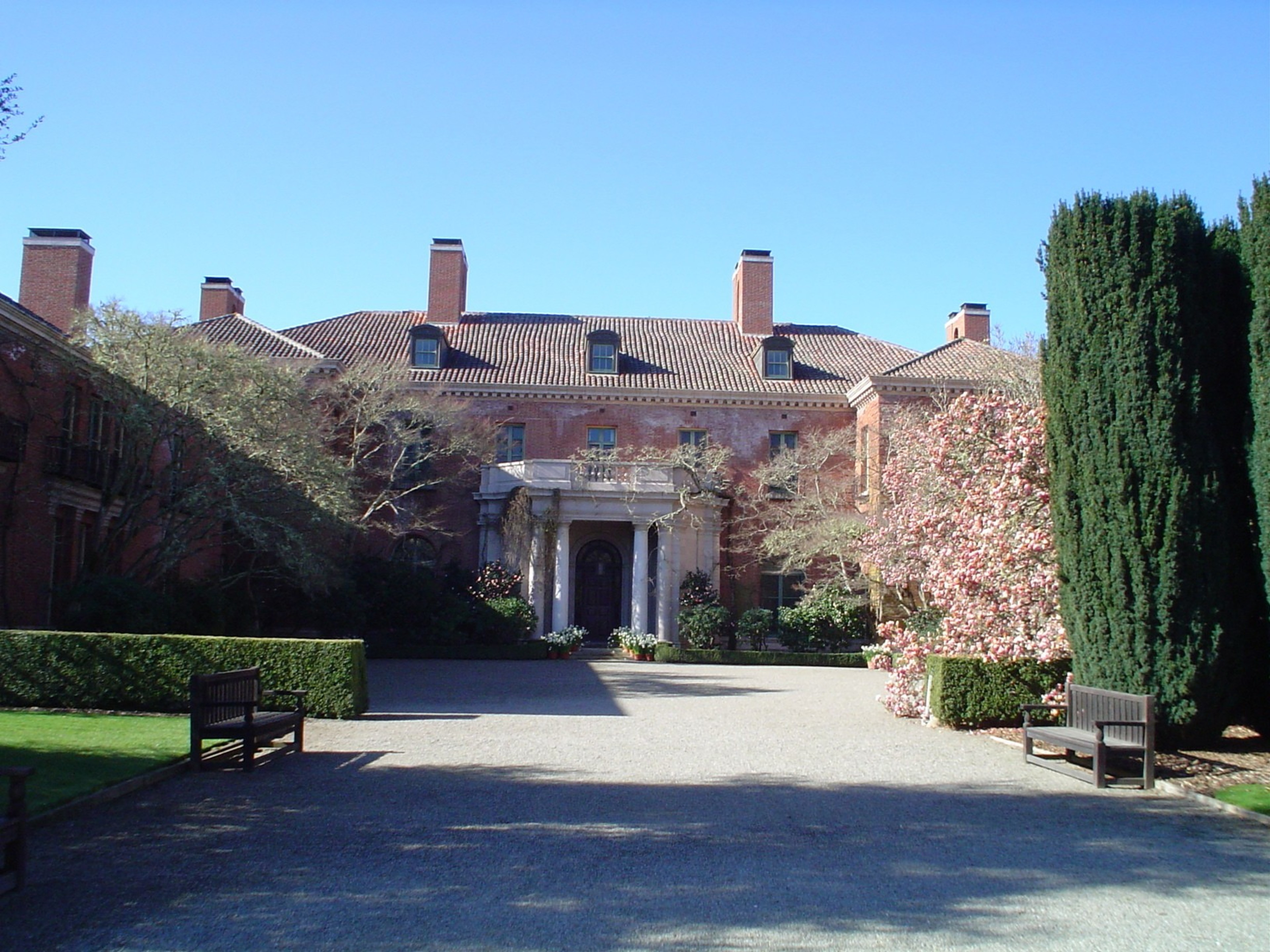 A large brick estate in the background on a sunny day.