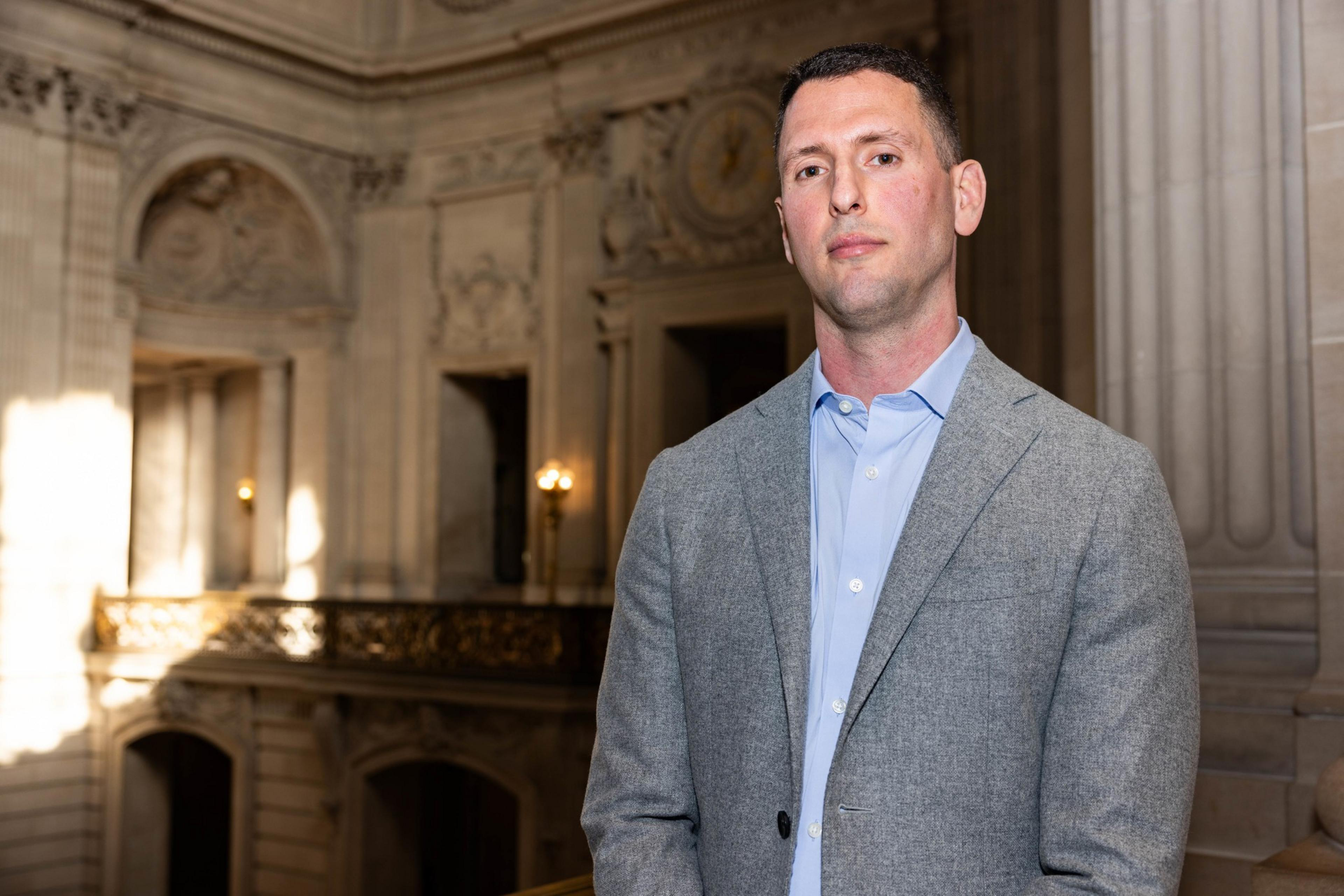 A man, Jay Donde, poses for a portait in San Francisco City Hall
