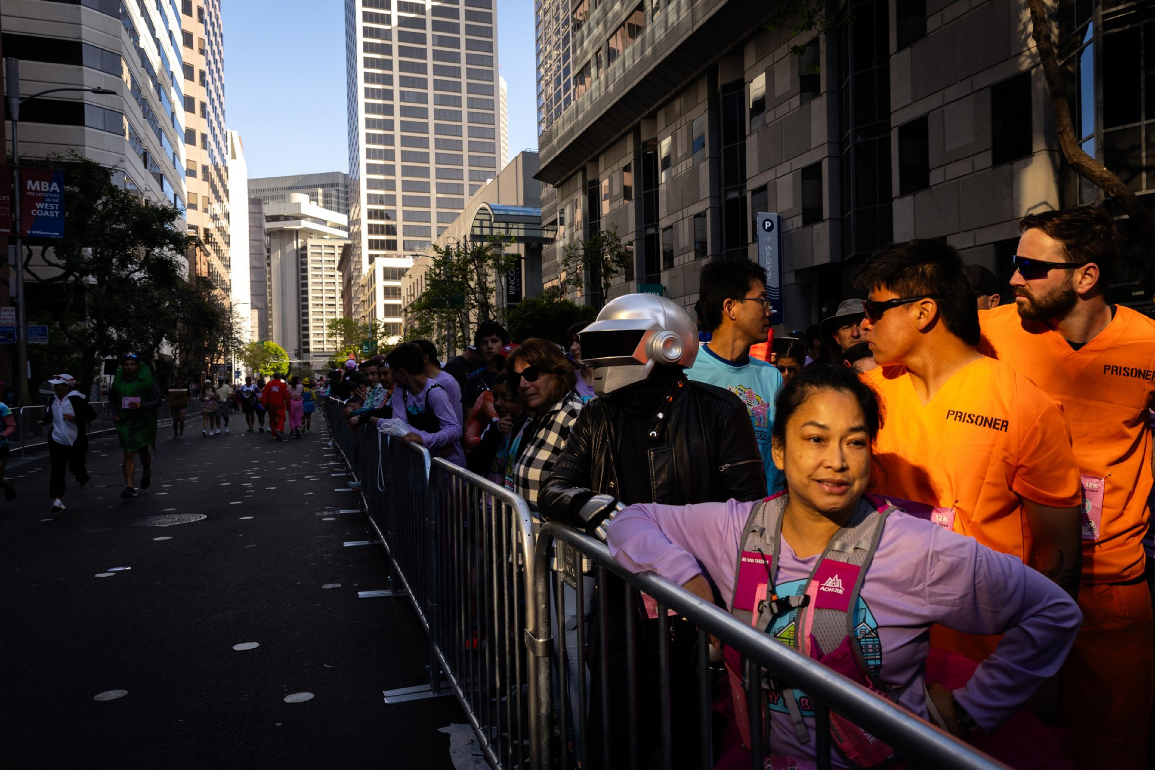 Costumed runners corralled along city streets get ready to run a foot race