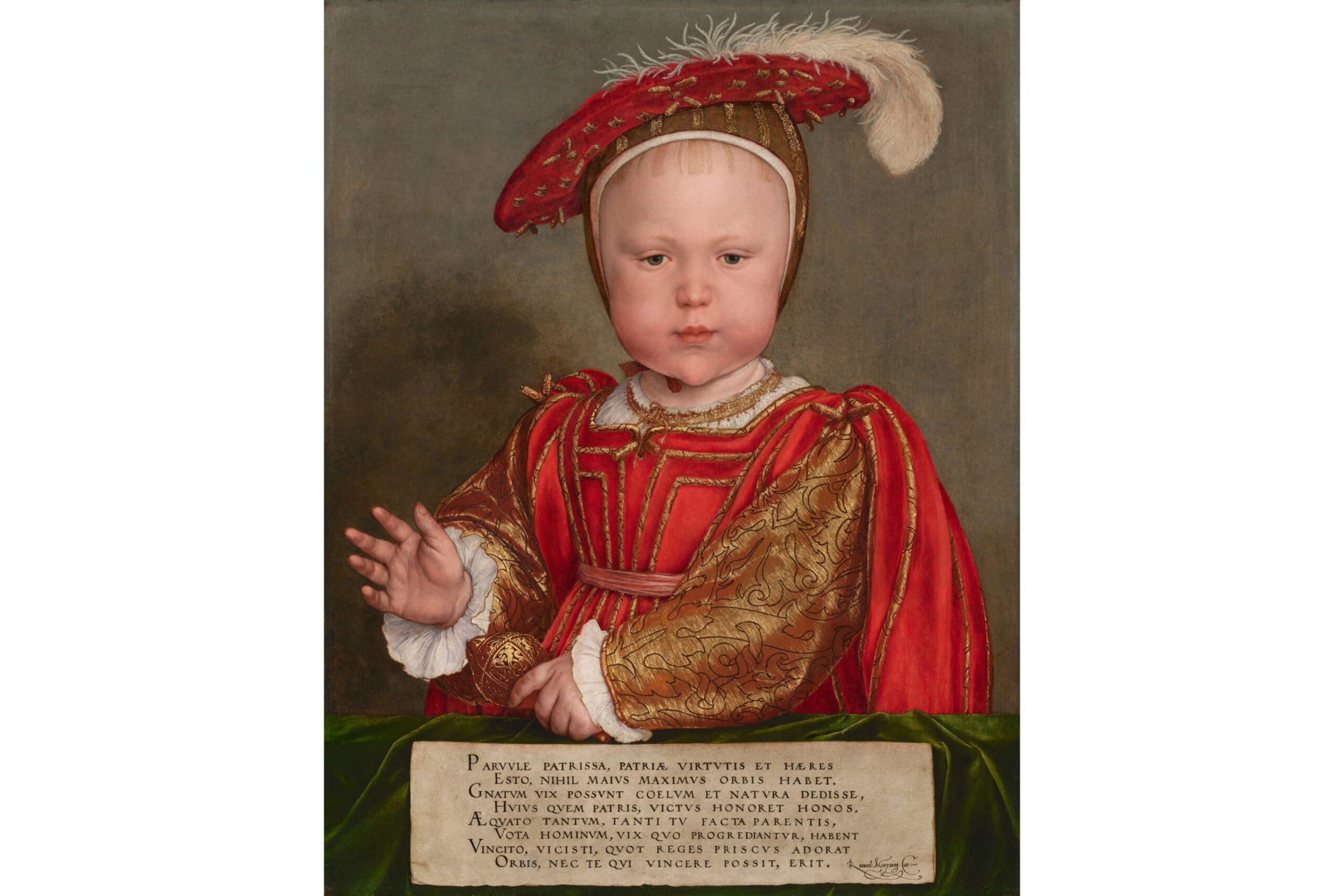 A young child in elaborate red and gold Renaissance clothing and a feathered hat raises one hand, resting the other on a table with Latin text.