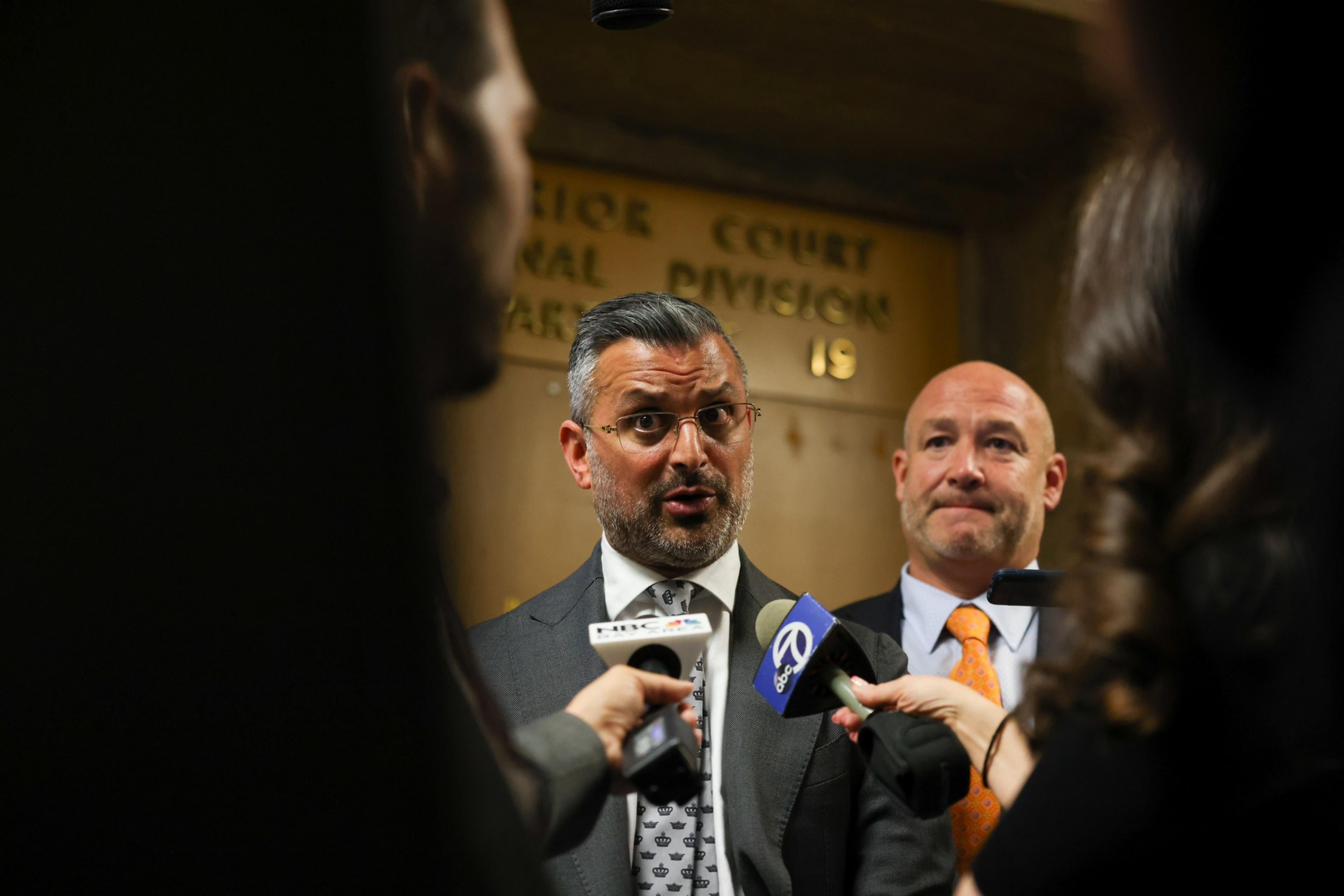 Two lawyers speak to the media.