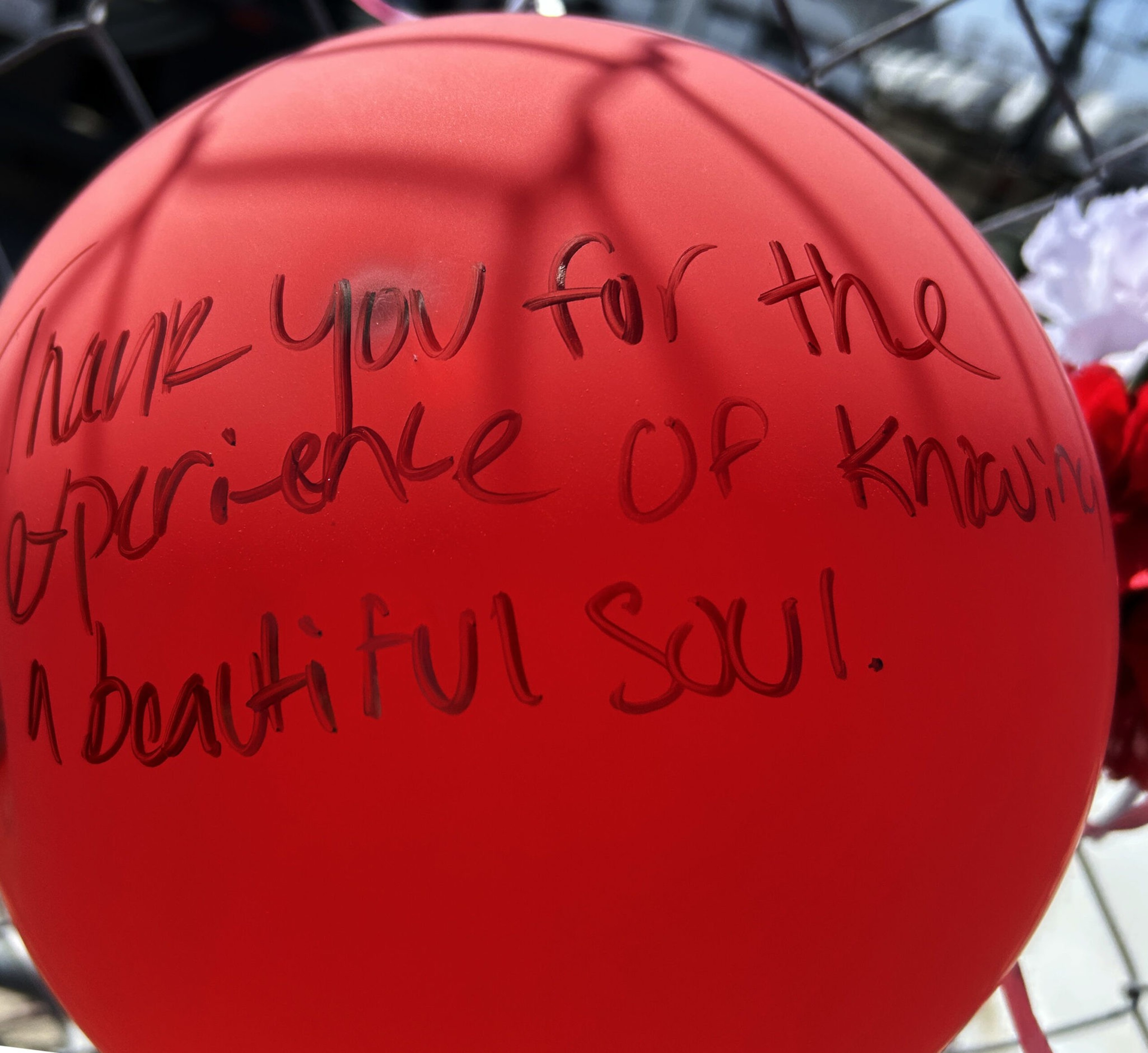 Red balloon with handwritten message that says, "Thank you for the experience of knowing a beautiful soul."