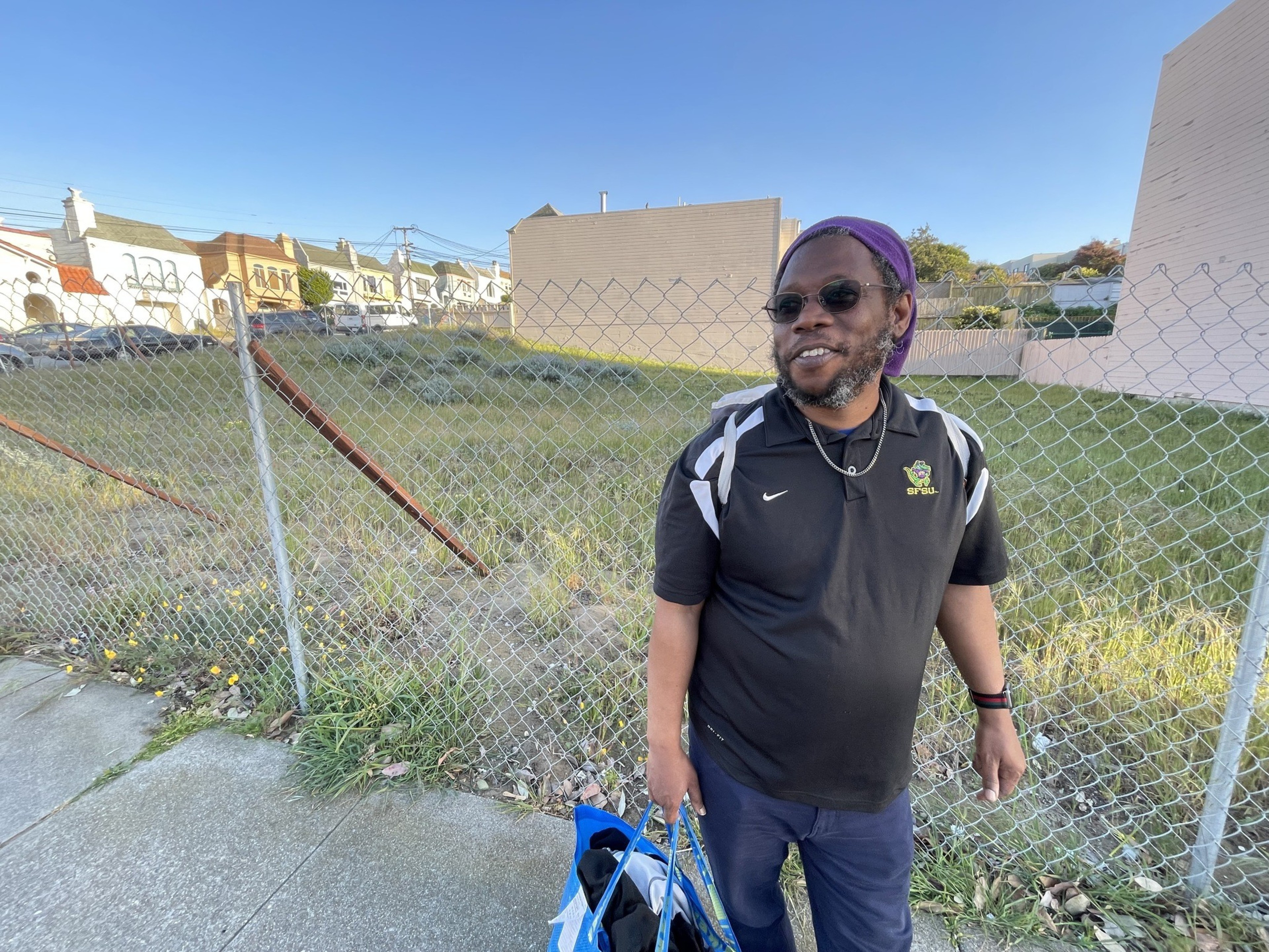 A man stands in front of a plot of land.