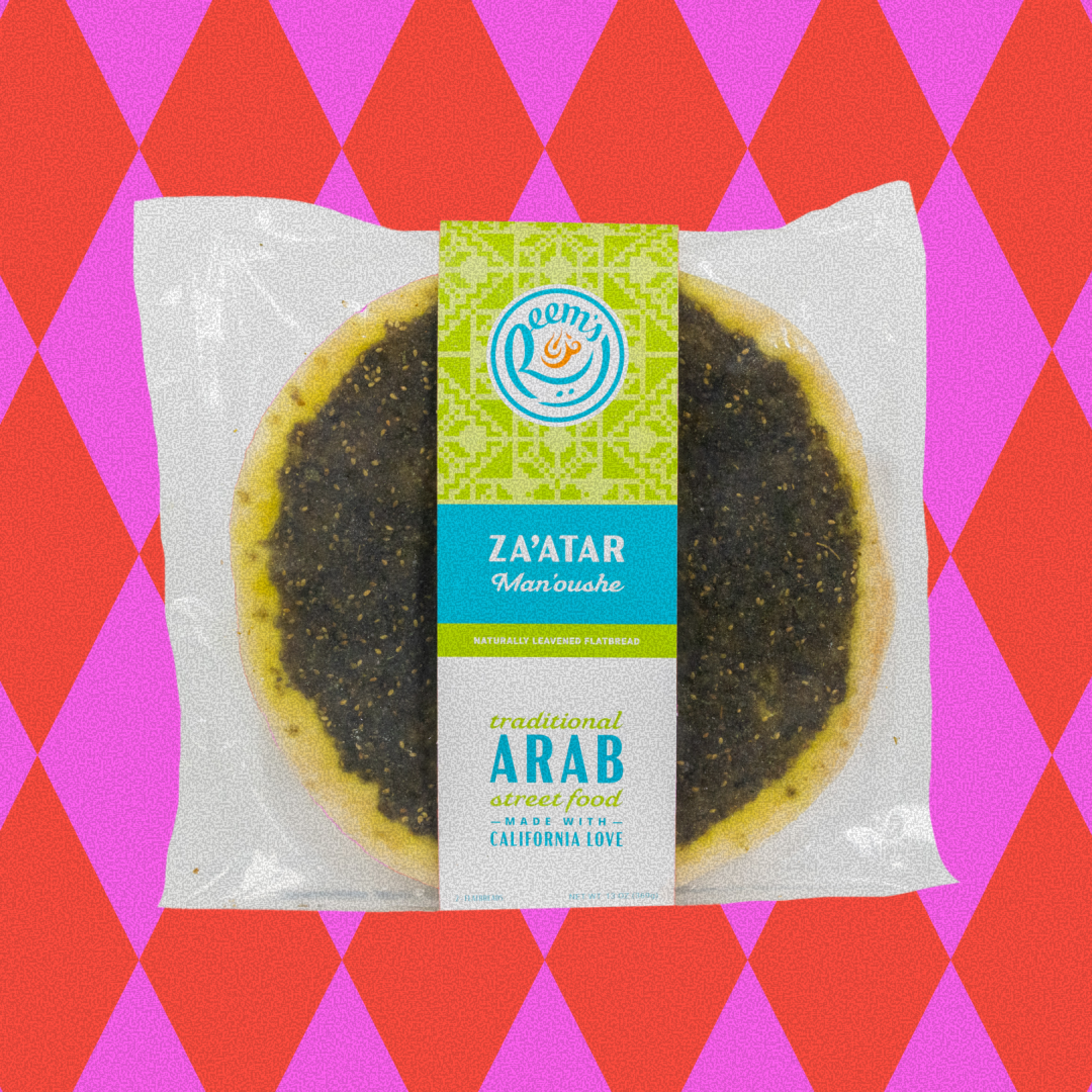 ZA'ATAR Man'oushe is a naturally leavened flatbread labeled as traditional Arab street food, packaged with a green and blue wrapper on a red and pink diamond pattern background.