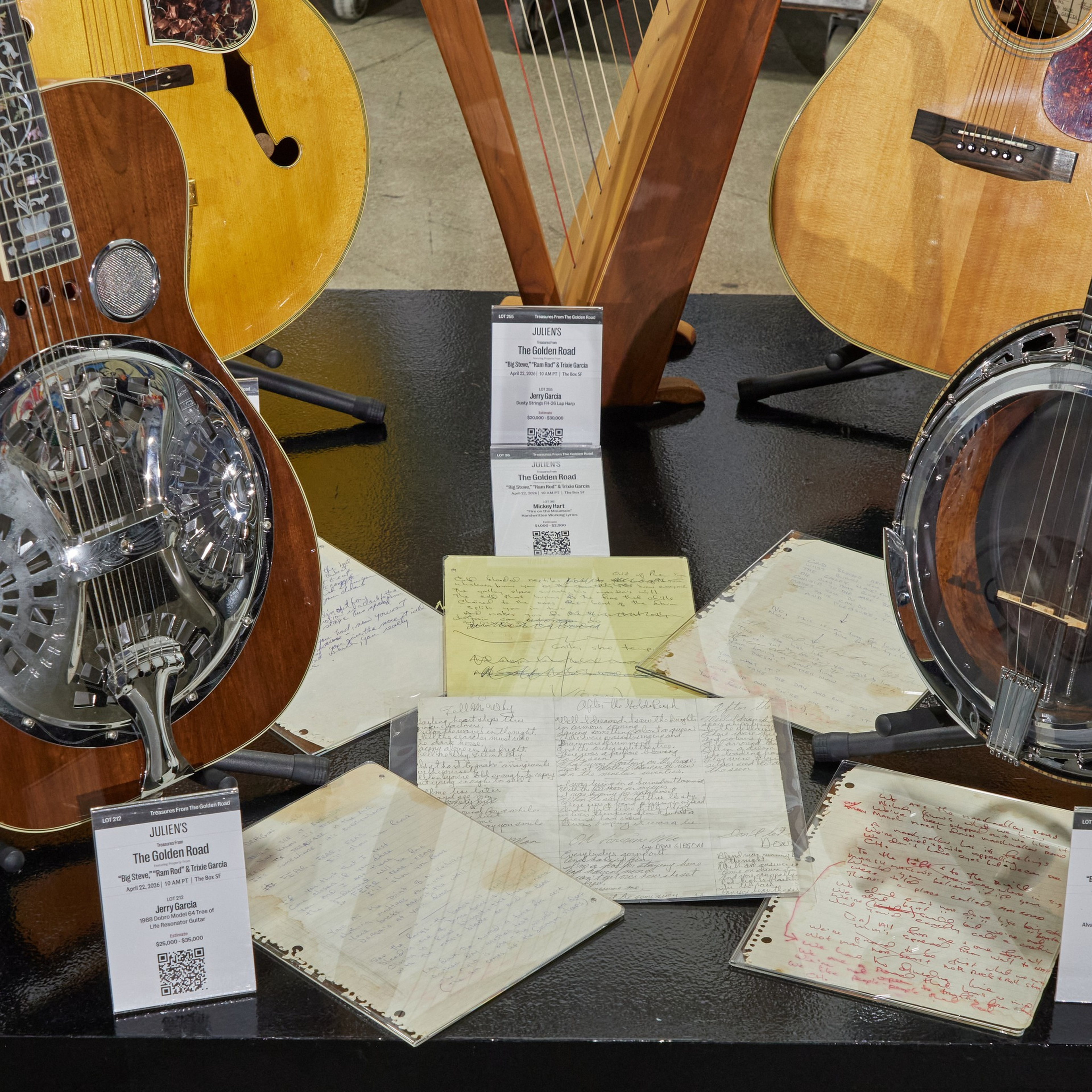 Various stringed instruments, handwritten song notes, and three informational placards with details about “The Golden Road” by Big Steve, Travis, and Jerry Garcia.