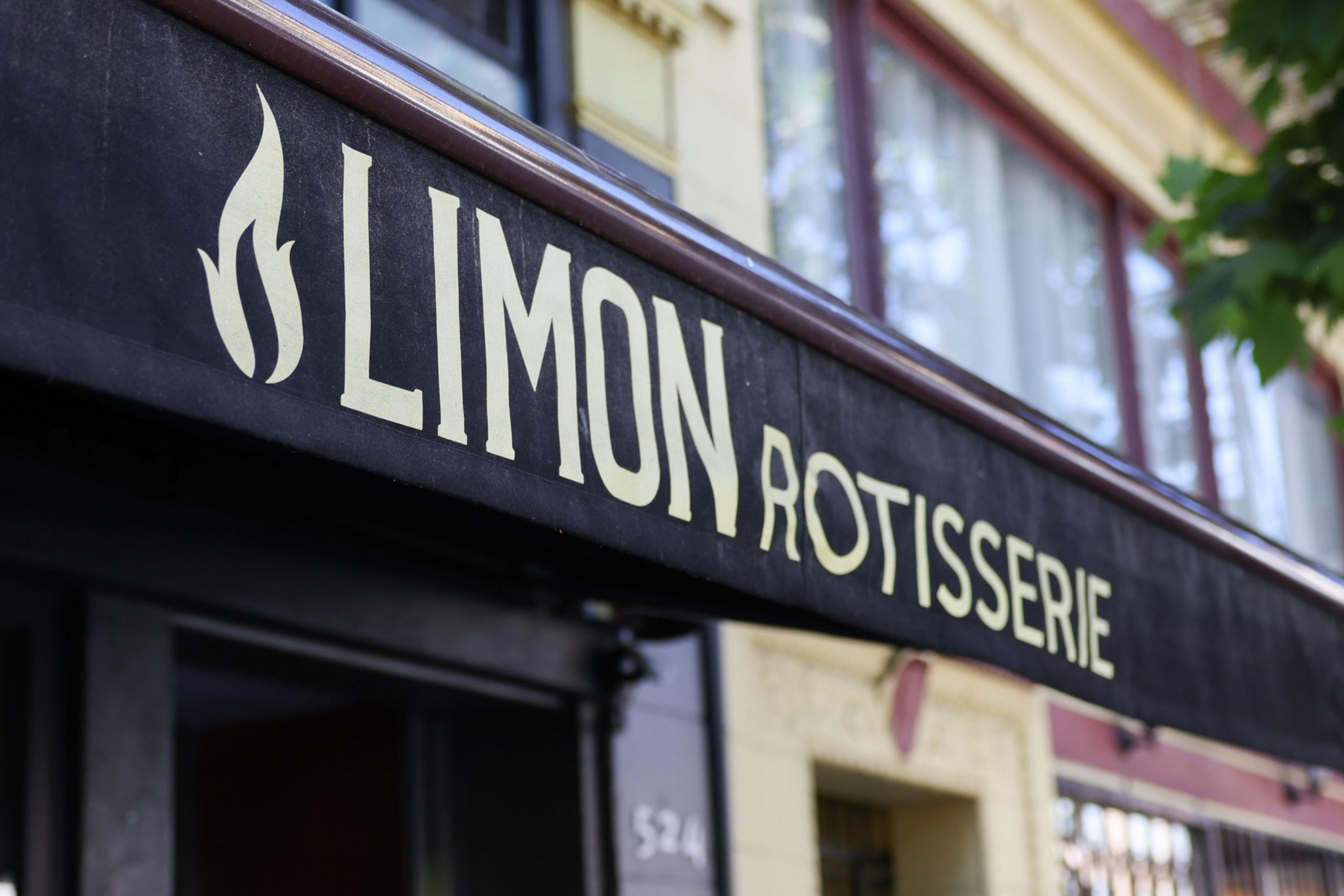 A black awning with a white flame logo and the words "LIMON ROTISSERIE" in large white letters hangs above a storefront.