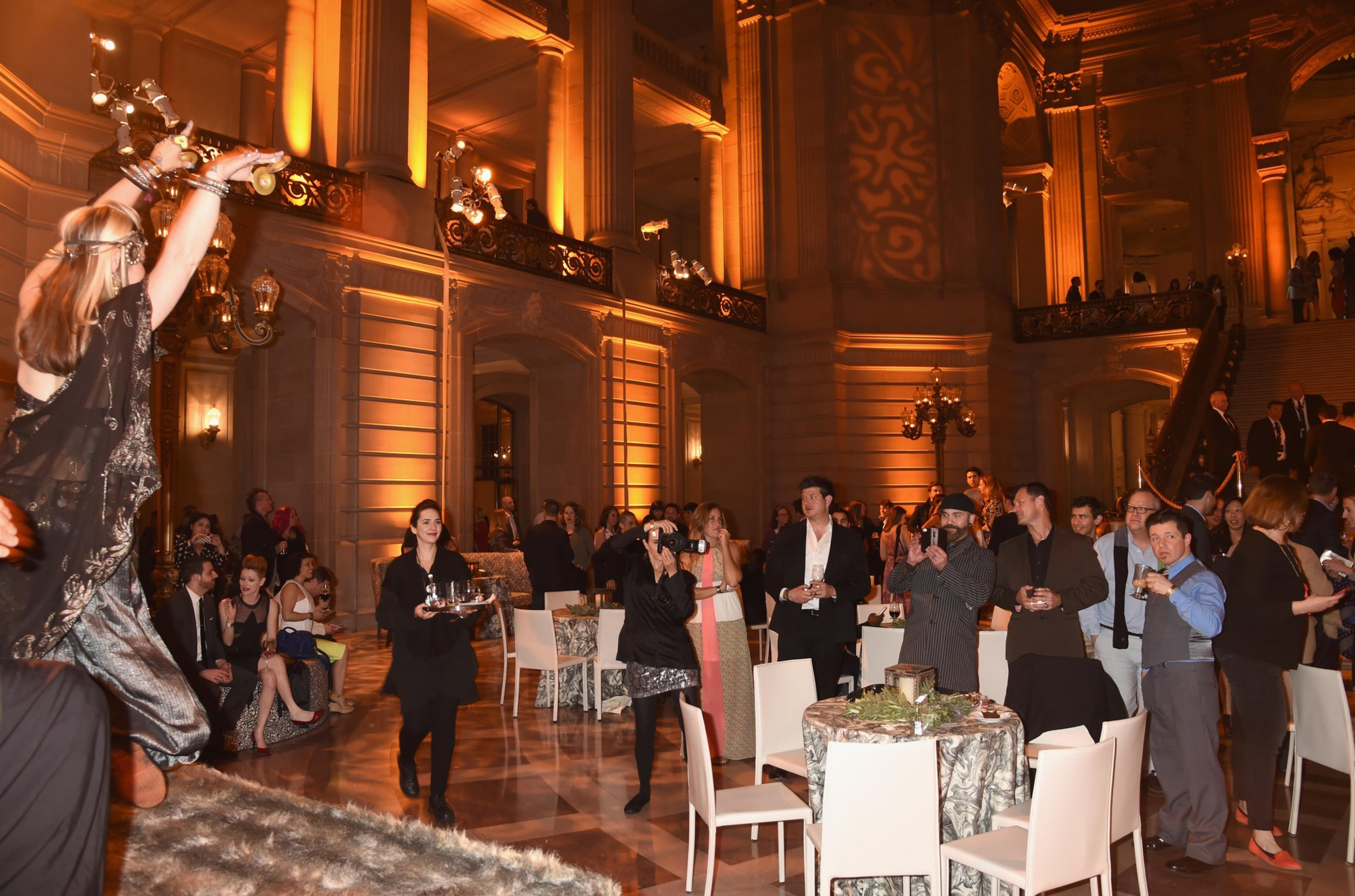 Dozens of people watch a dancer perform in the center of San Francisco's San Francisco City Hall with the interior space lowly lit in an auburn color. The event for an after party for HBO's &quot;Game of Thrones&quot; Season 5.