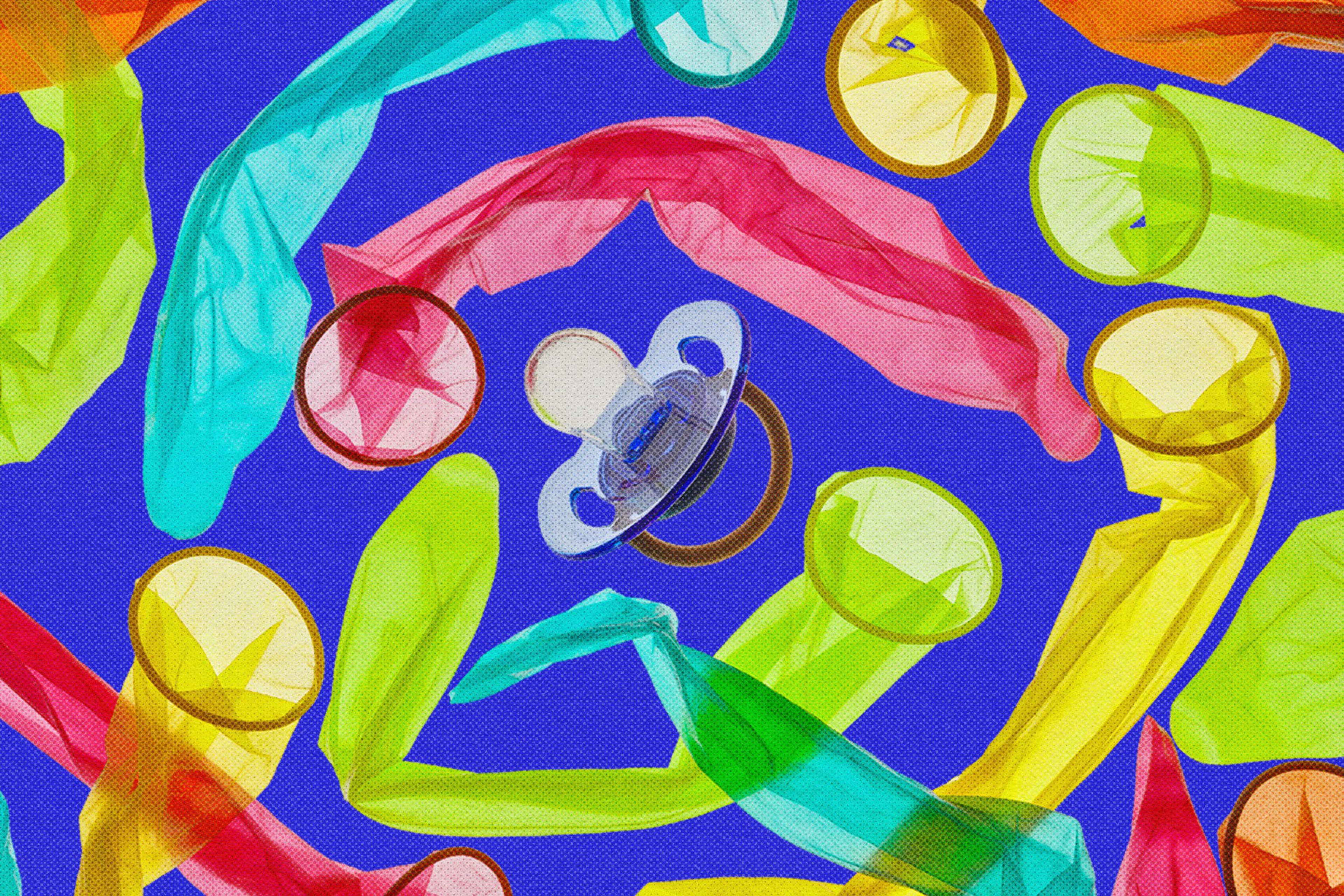 A clear baby pacifier lies in the center surrounded by various colorful, uninflated condoms on a bright blue background.