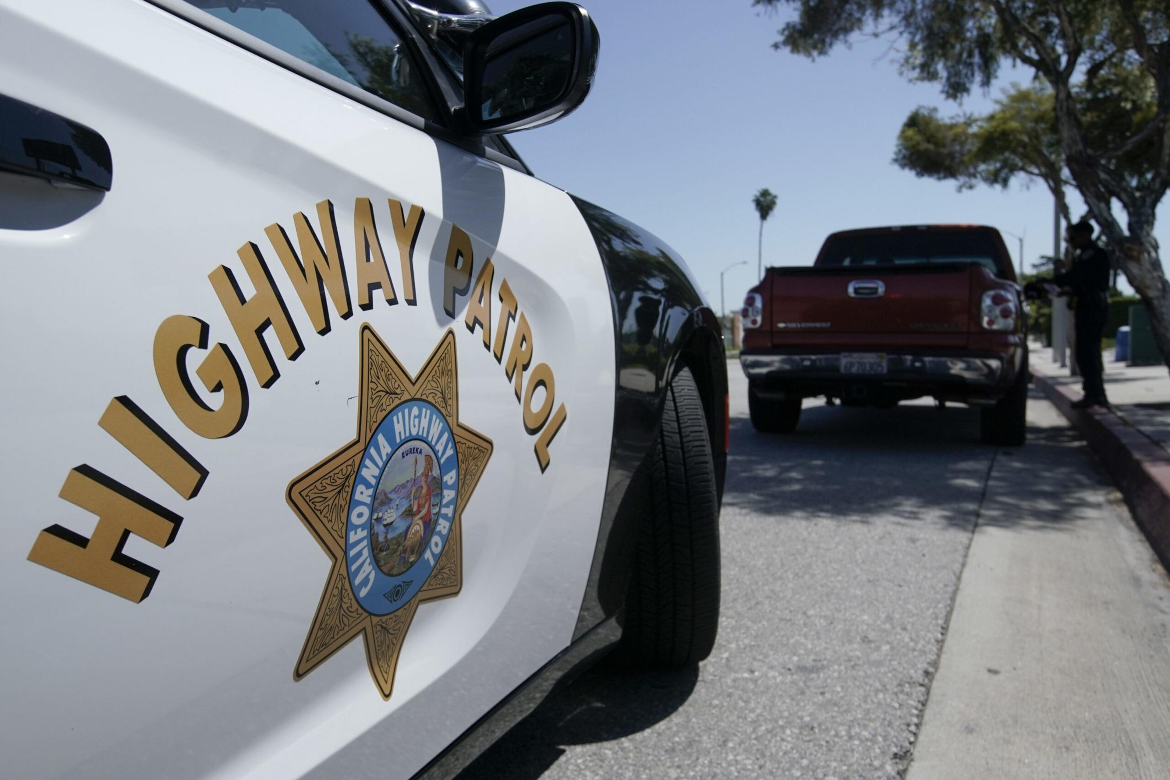 The door of a law enforcement patrol vehicle emblazoned with the California Highway Patrol logo.