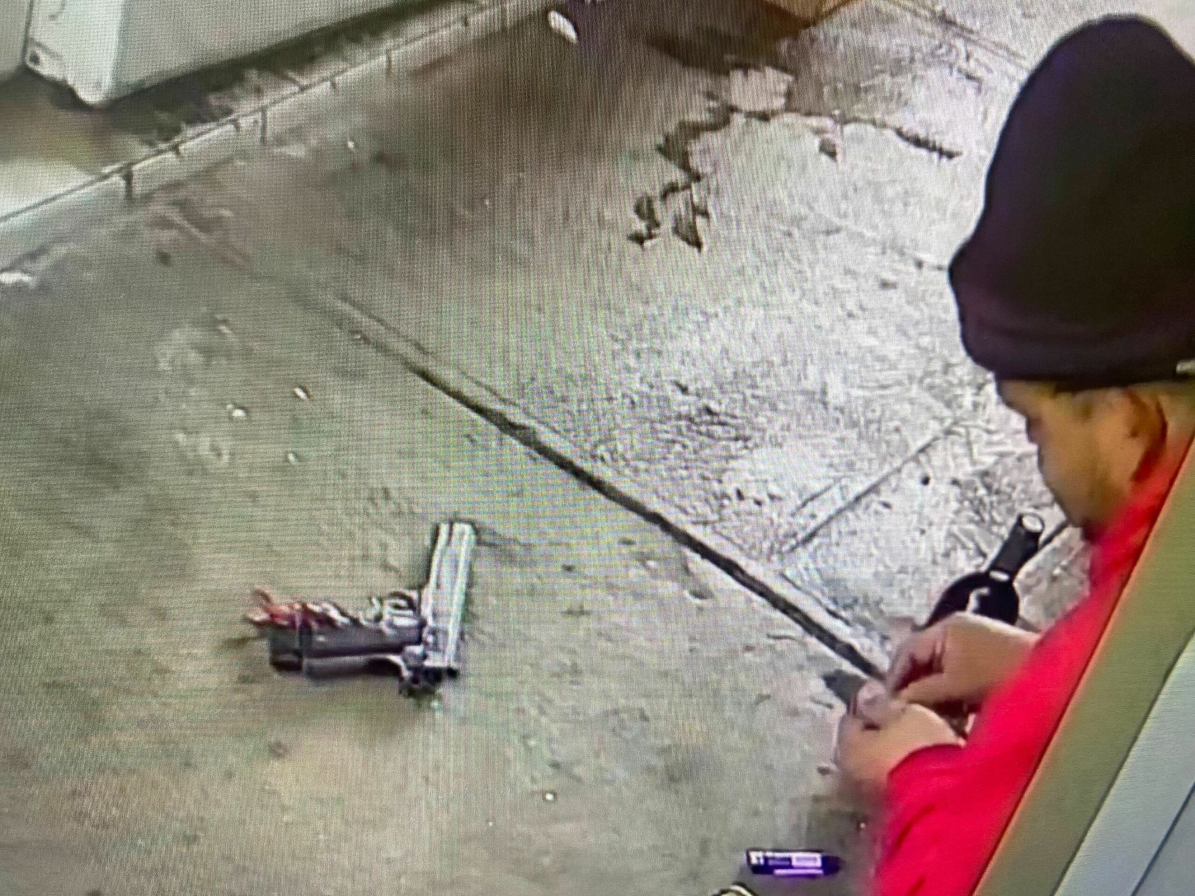 A man holds drugs in his hand near a handgun.