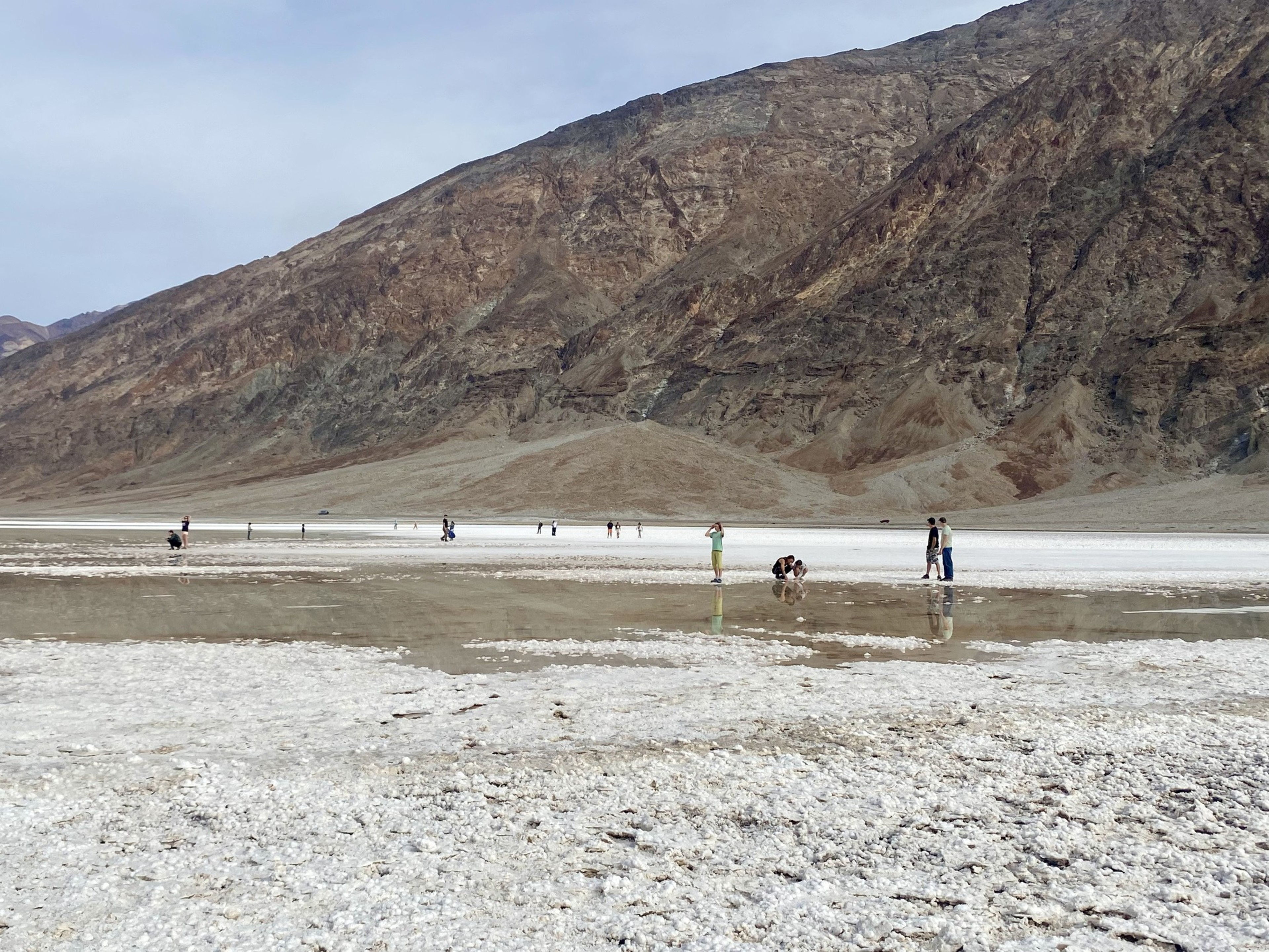 People on the shore of a lake in a desert.