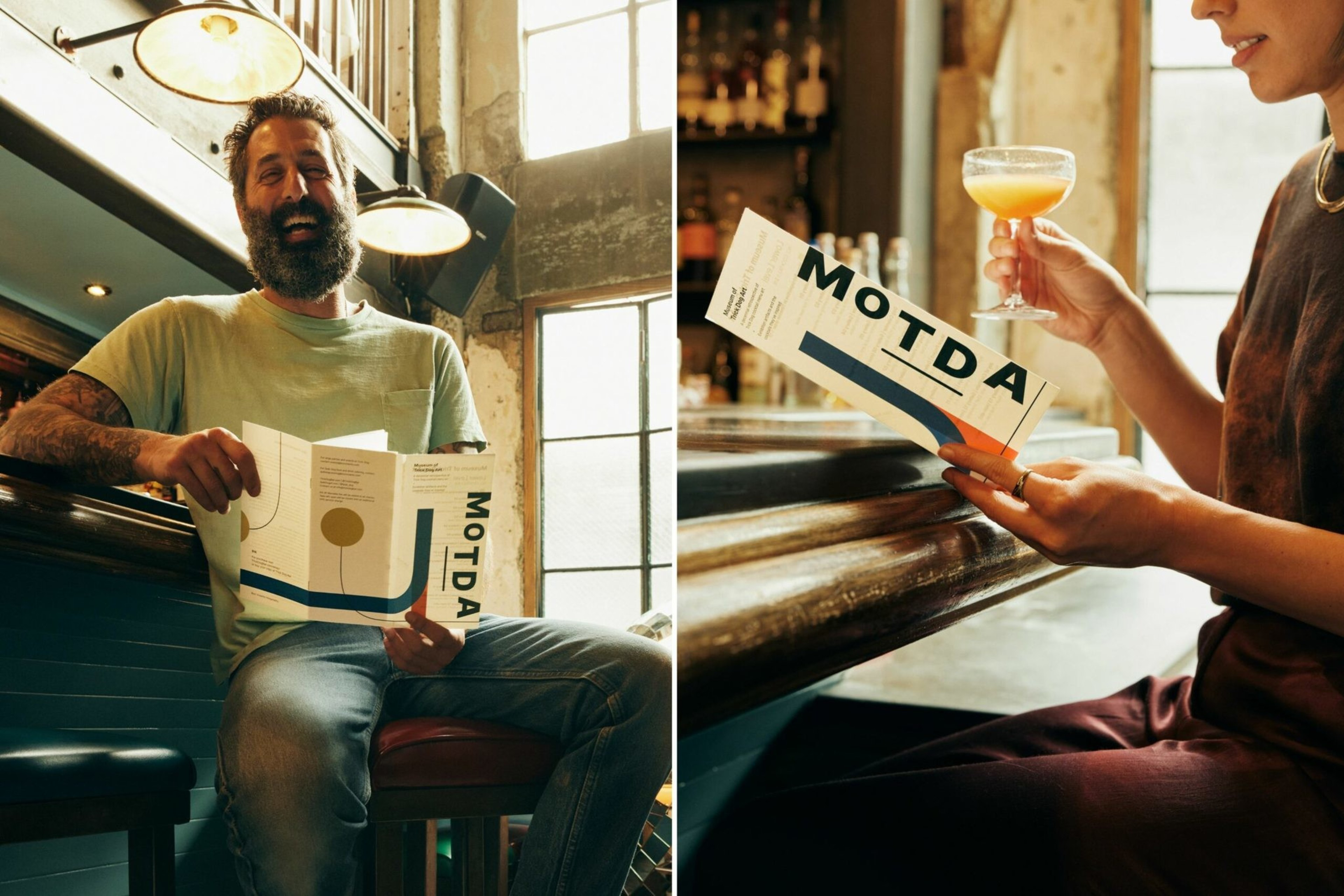A bearded man sits laughing at a bar holding a MOTDA menu, while a woman holds the same menu and a cocktail in a coupe glass.