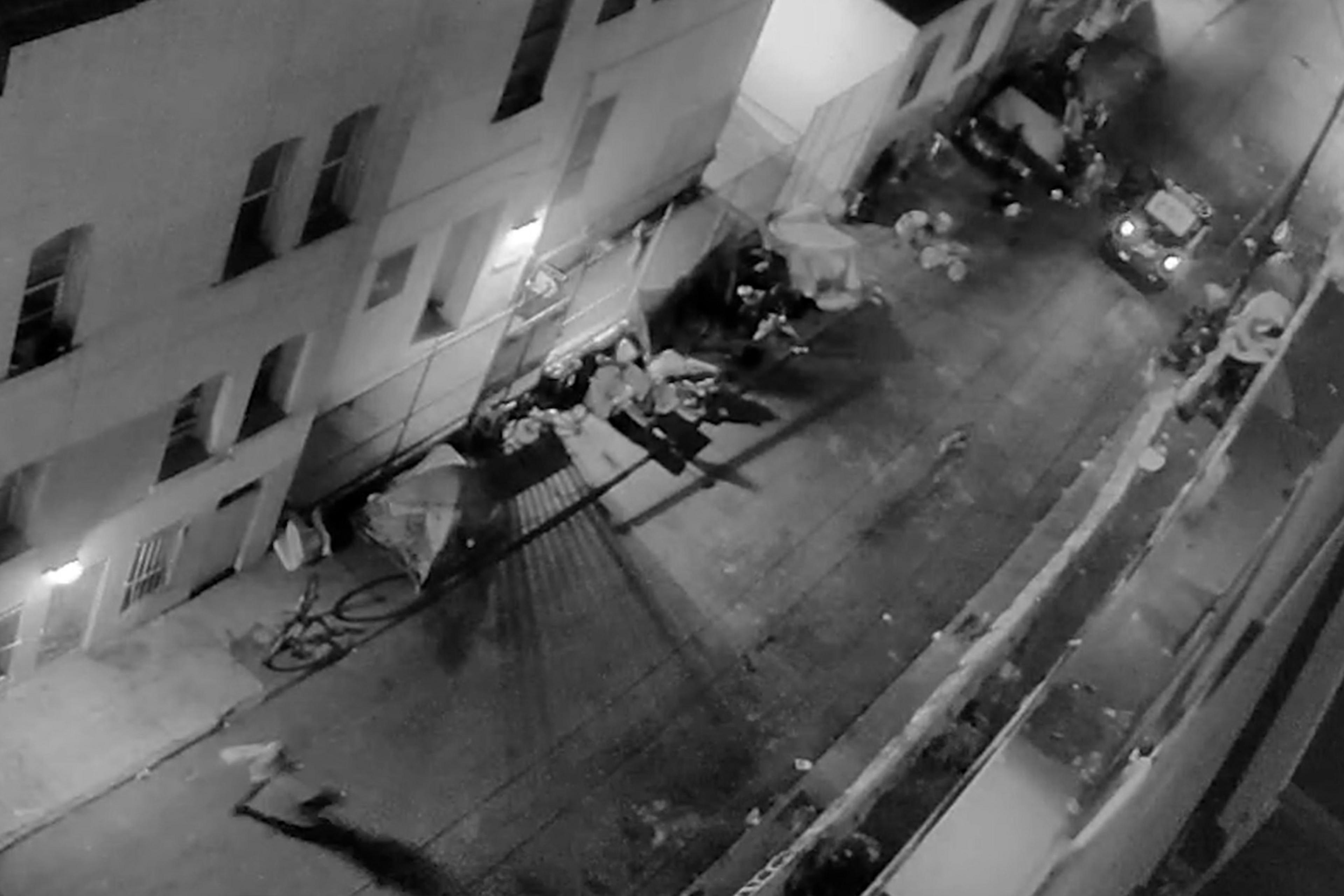 A man is seen running from police in a San Francisco alley near a tent encampment.