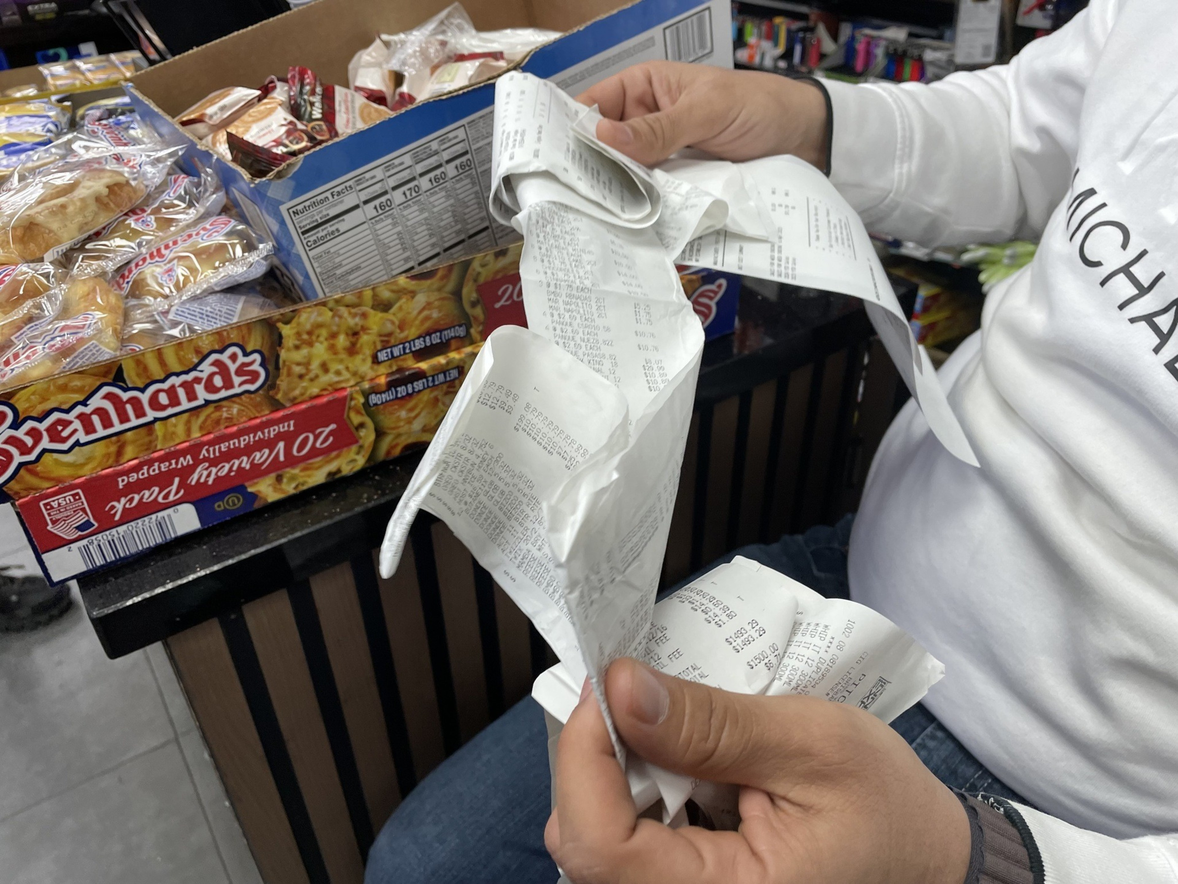 A man shows a pile of reciepts.