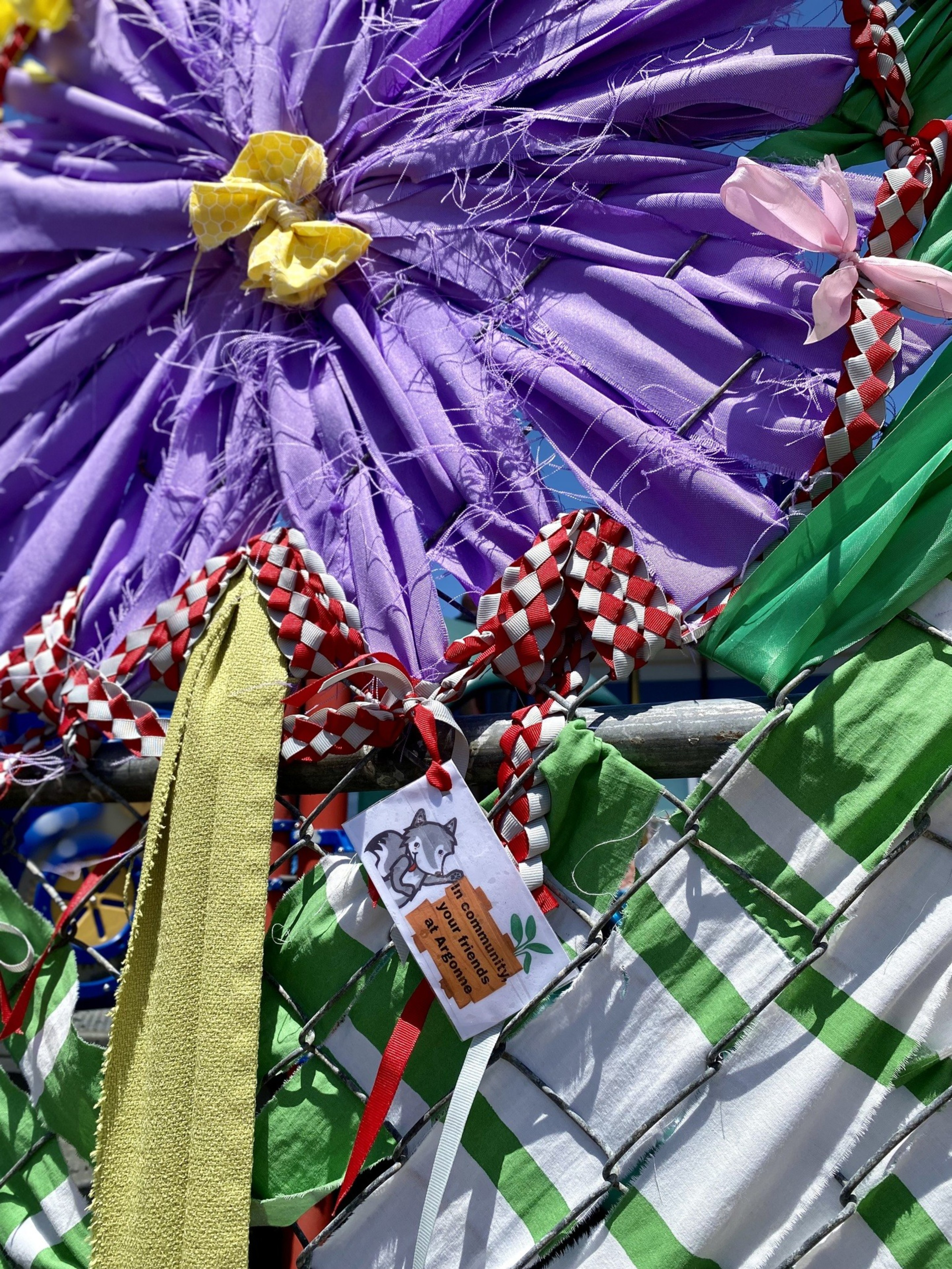 A photo of community members decorating a fence.