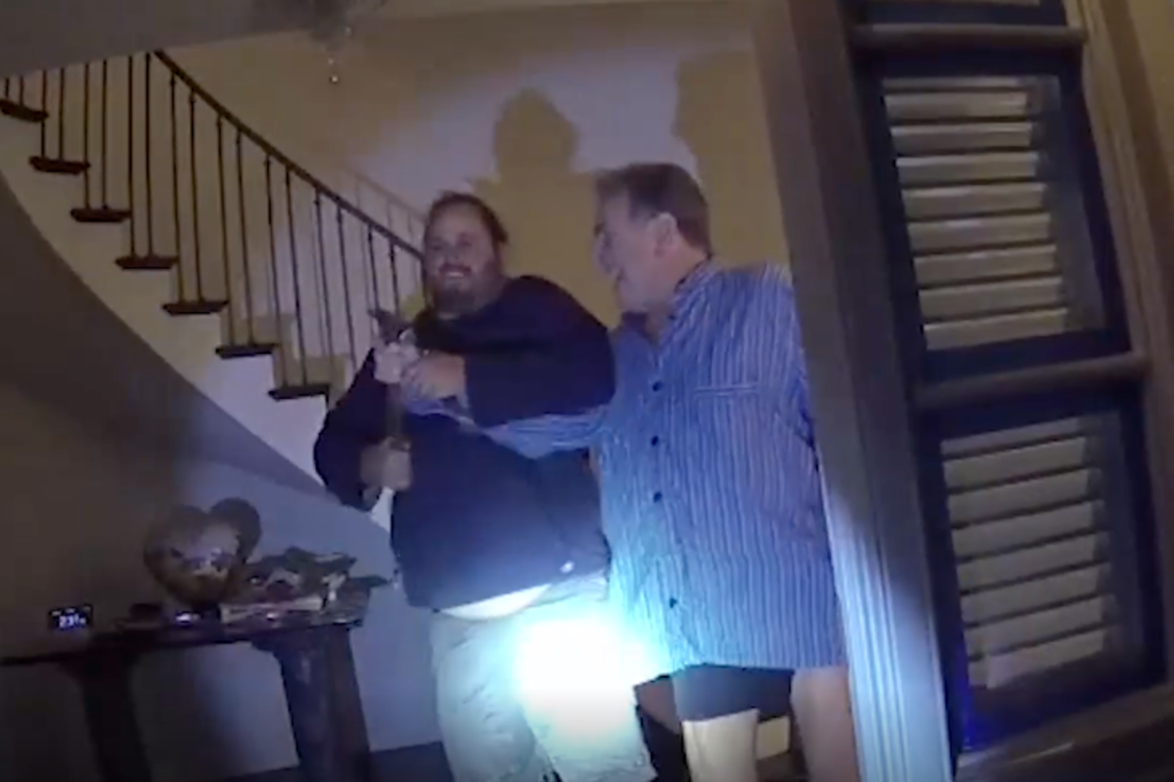 A still from policy body cam footage showing David Depape and Paul Pelosi struggle over a hammer in the threshold of a home.