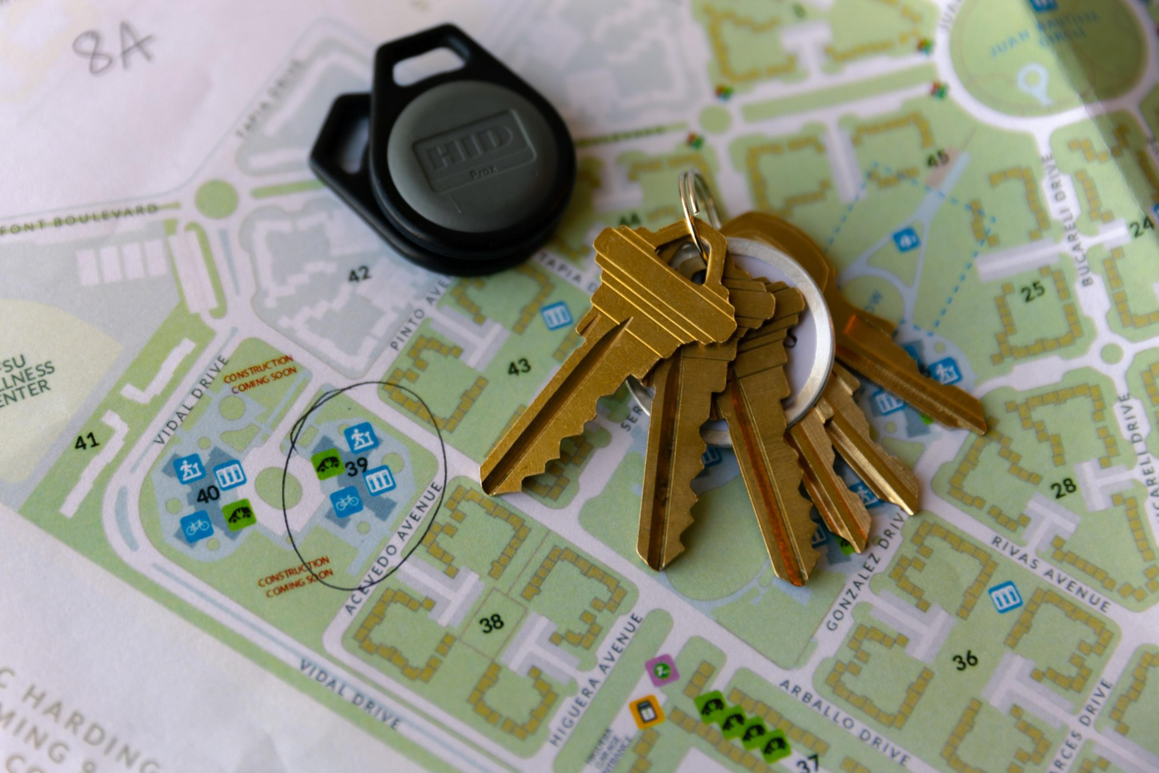 A cluster of gold keys on a ring and a black key fob rest on a detailed map, with a marked area labeled &quot;Construction Coming Soon.&quot;