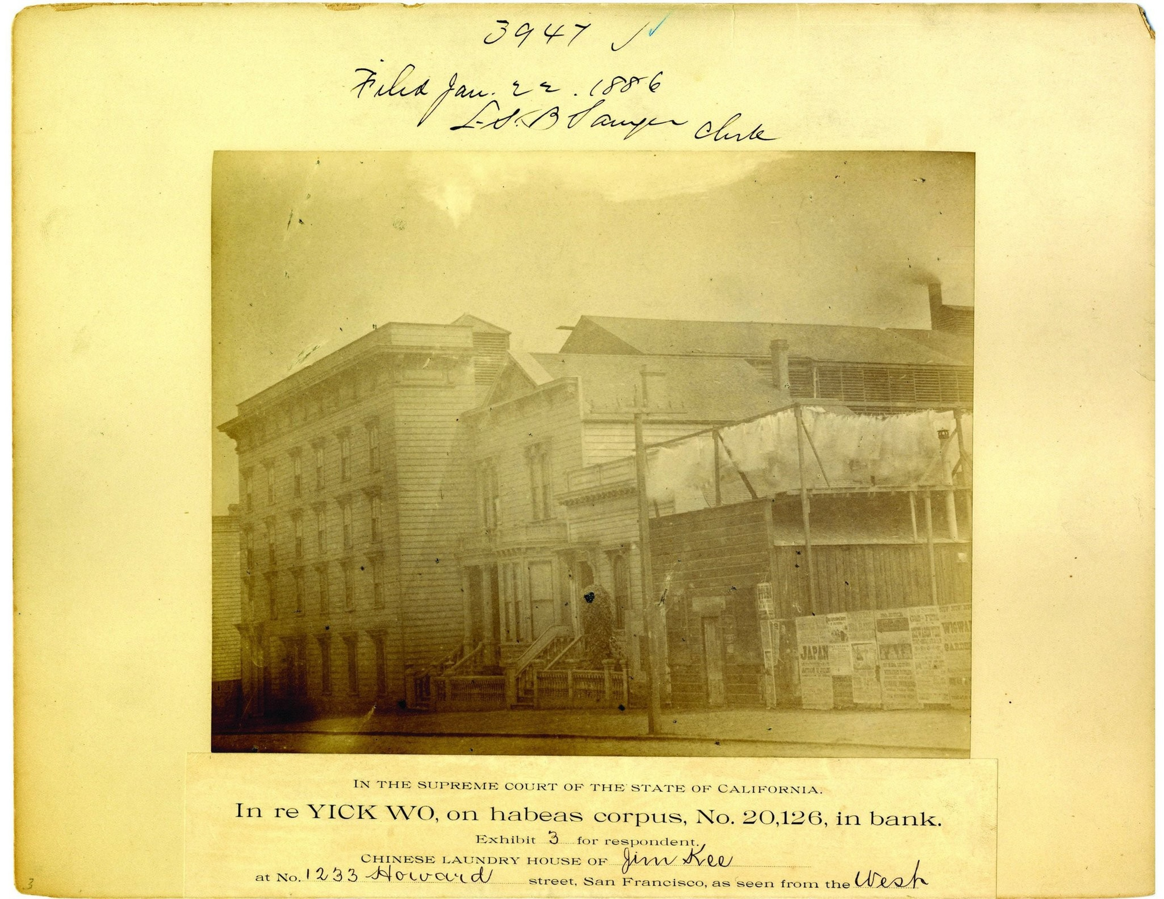 A sepia photograph depicts a block of aging wooden buildings in San Francisco, including the Chinese Laundry House of Jim Kee at 1233 Howard Street, with handwritten legal text above and below.
