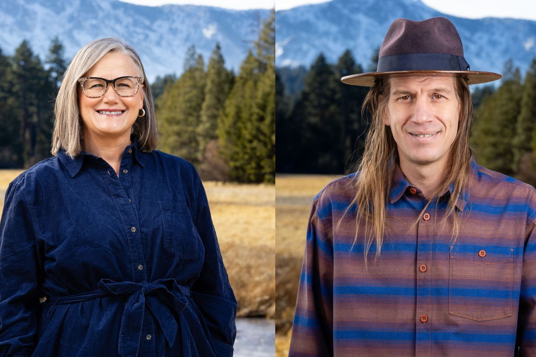 A smiling woman with gray hair and glasses wears a blue dress, standing outdoors next to a man with long hair, a hat, and a striped shirt, with mountains and trees behind them.