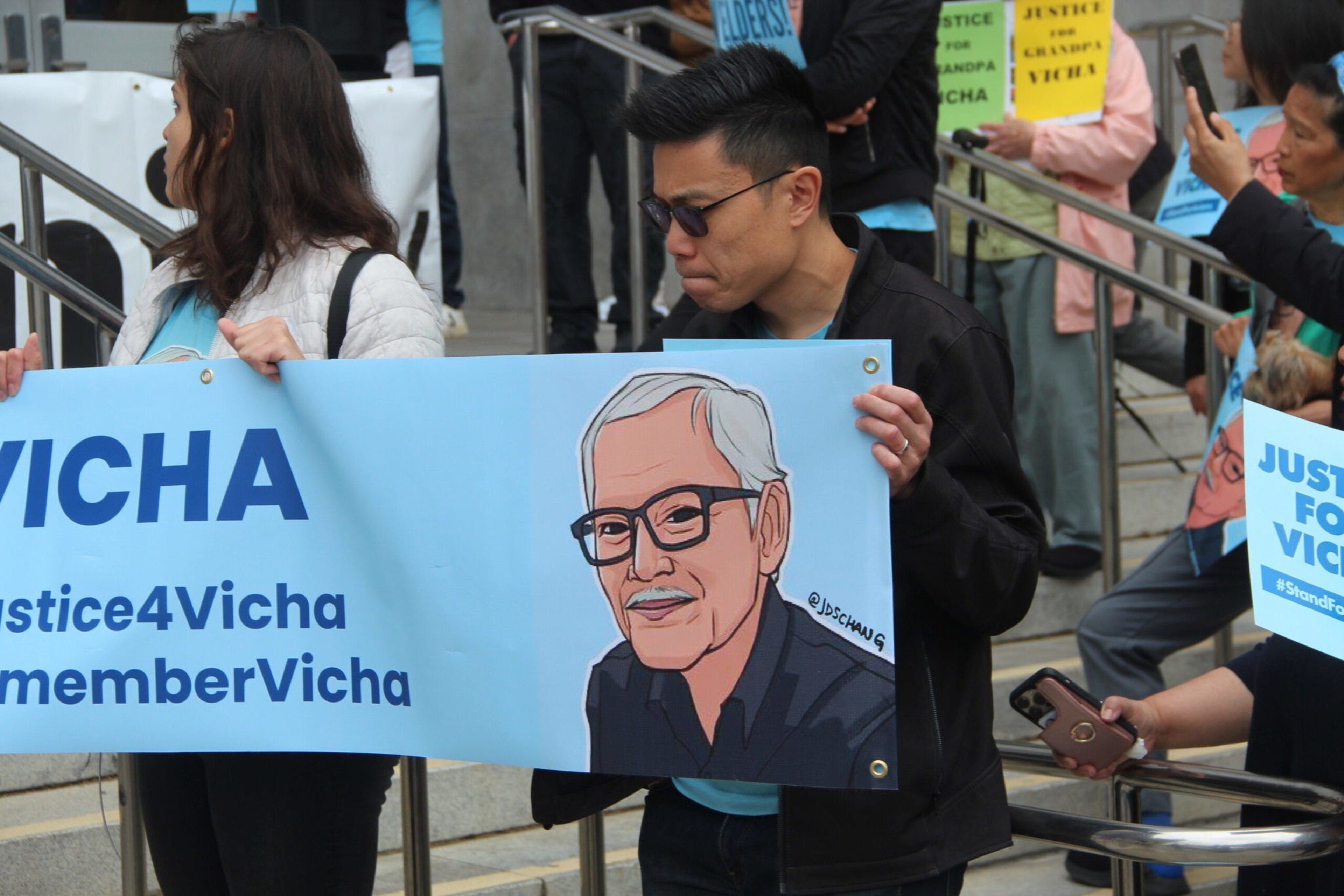 Protesters hold the banner showing "Grandpa Vicha" in San Francisco on June 23, 2023.