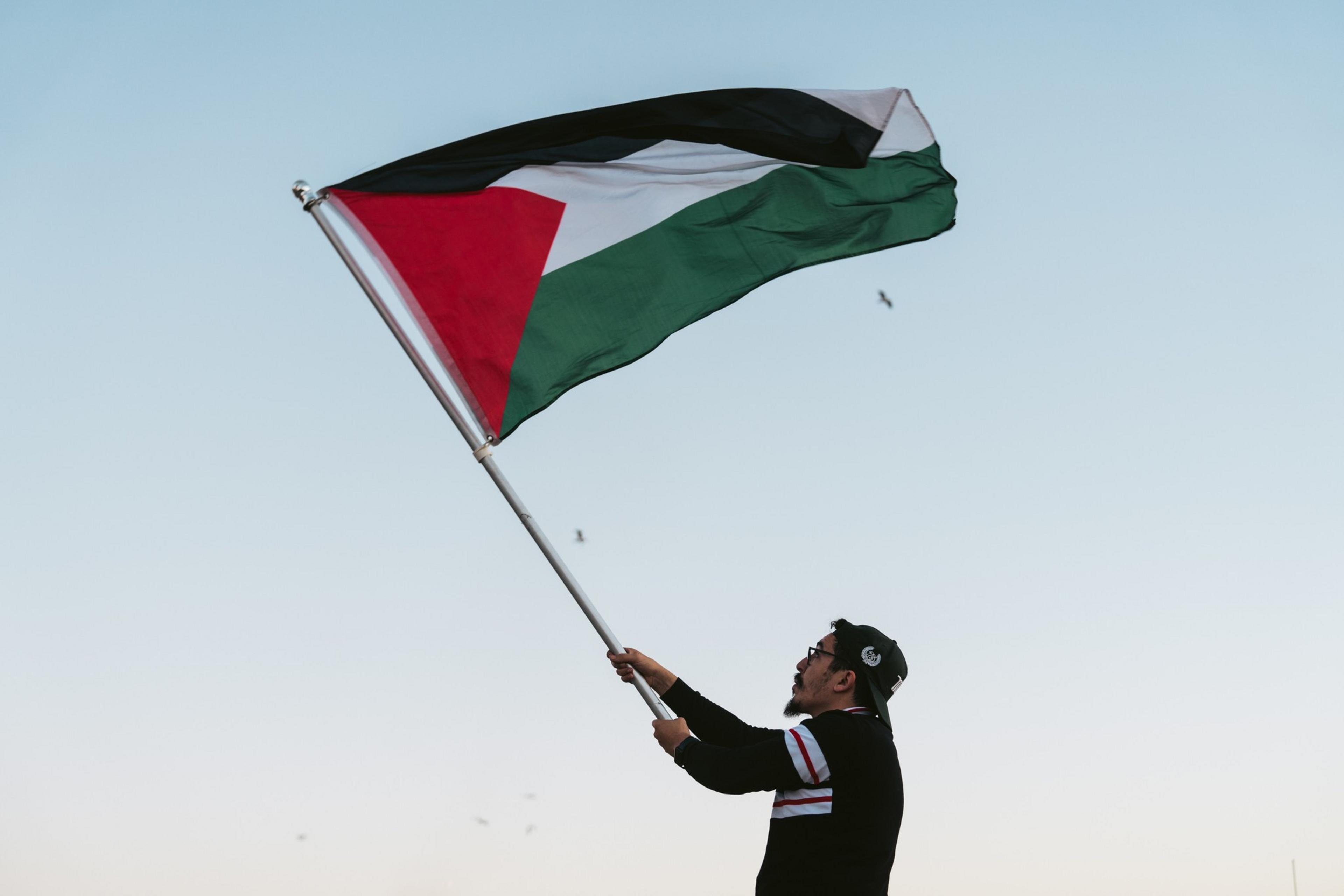 A man waves a Palestinian flag.