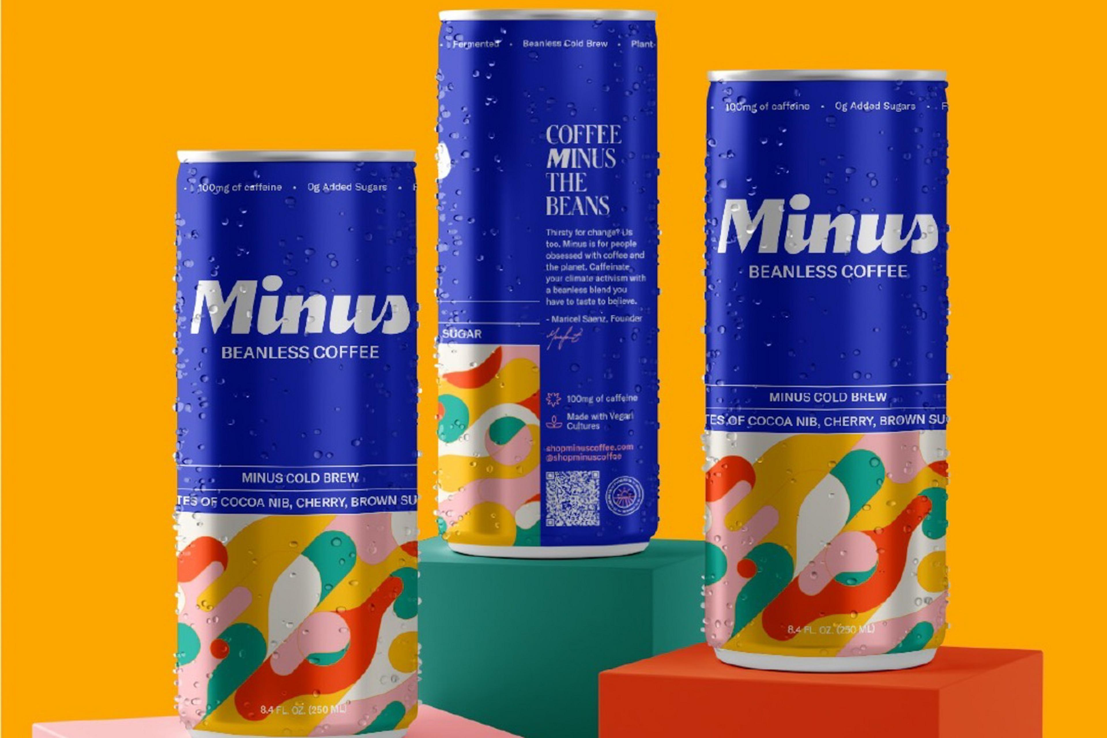 Three blue cans of Minus Beanless Coffee with colorful abstract designs sit on red, green, and pink platforms against an orange background.