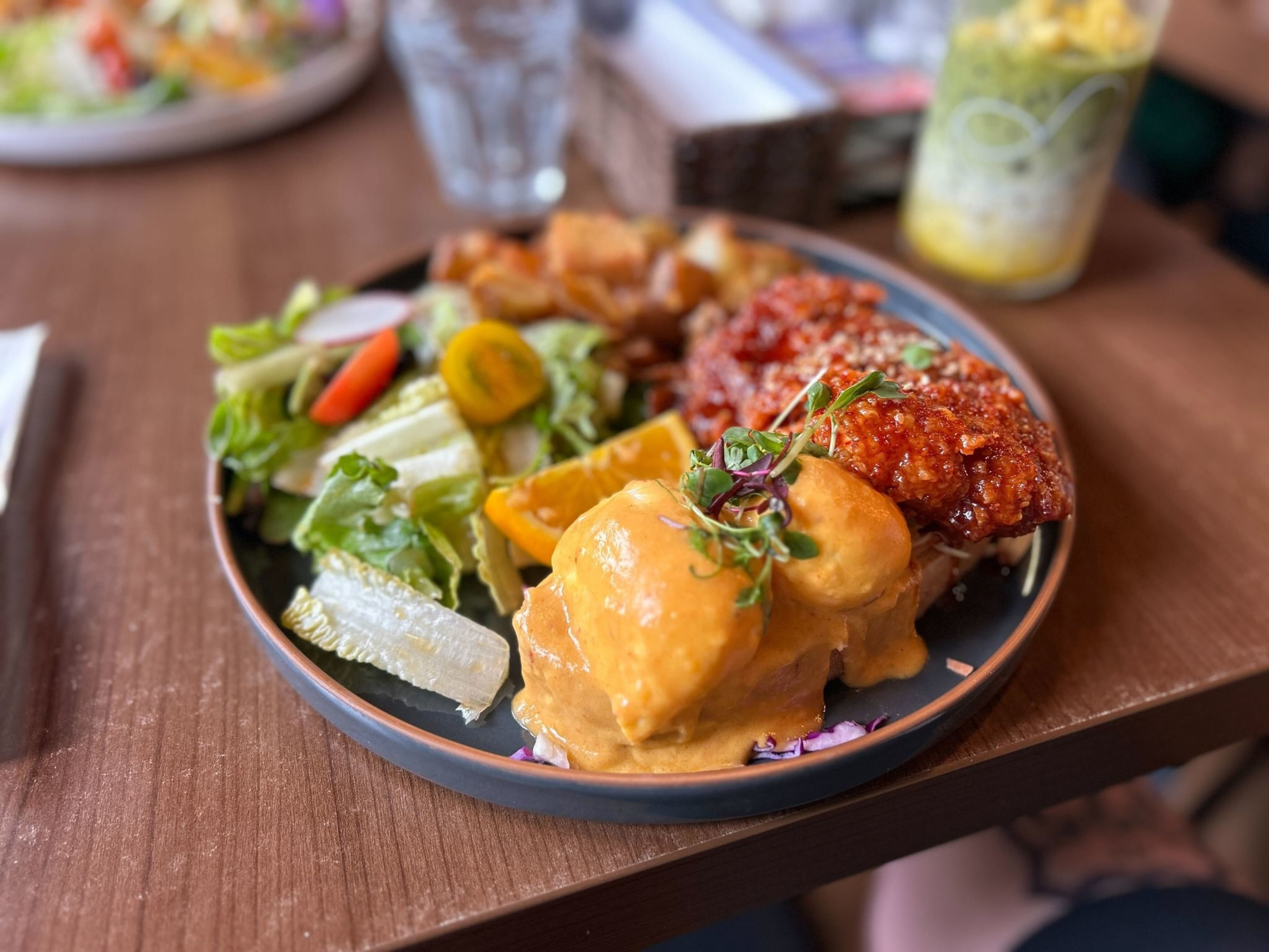 a plate of fried chicken benedict on a restaurant table