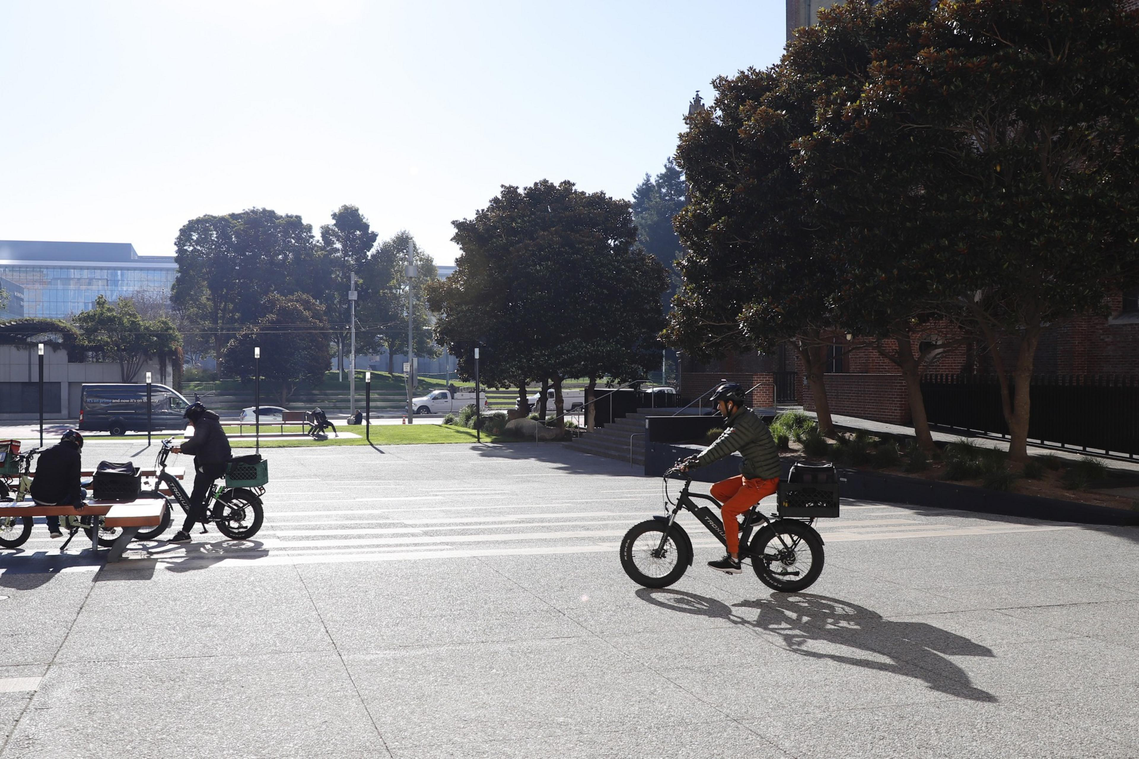 Cyclists ride through an open plaza area near Mission St. between 3rd and 4th Street.