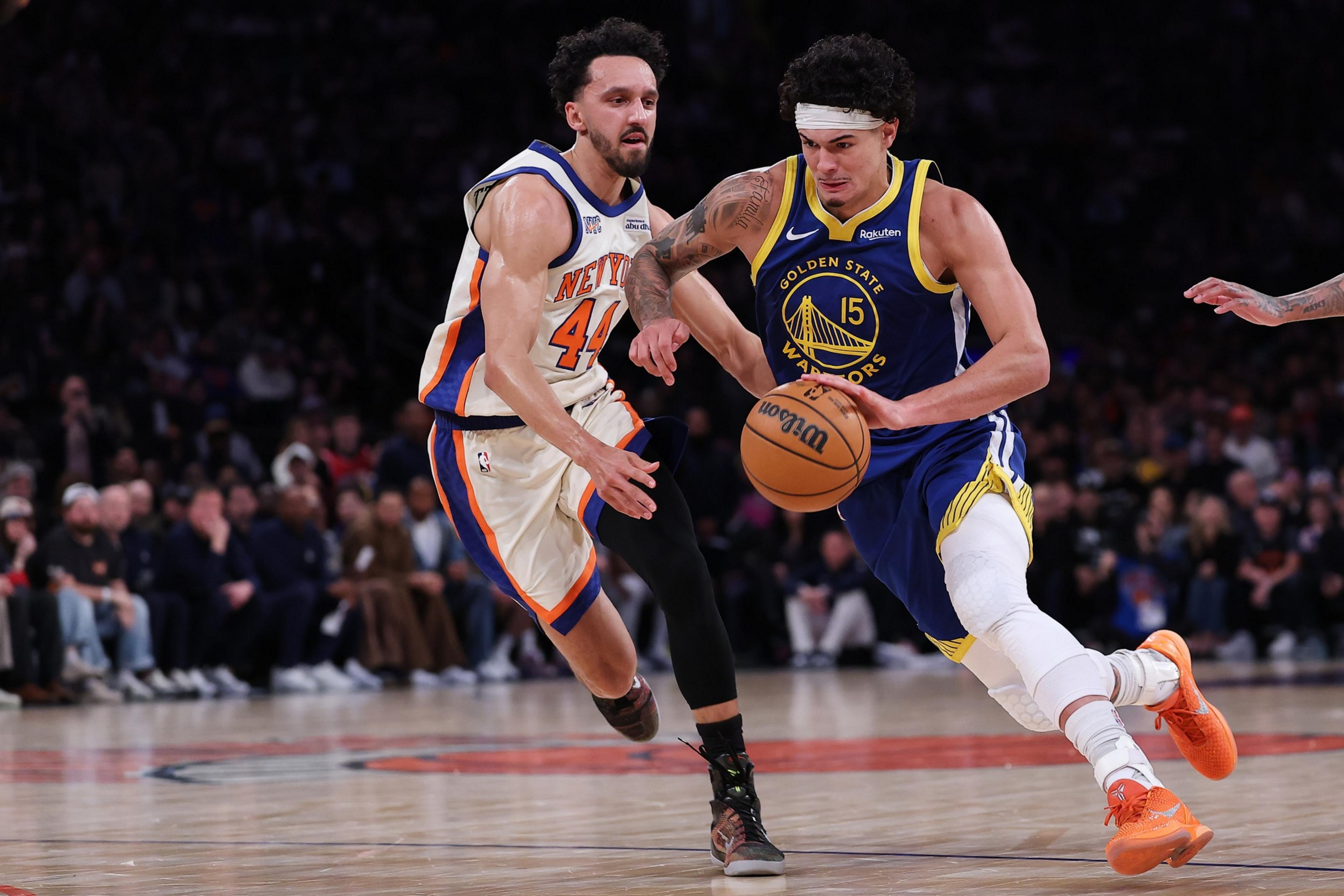 A Golden State Warriors player dribbles past a New York Knicks defender ...