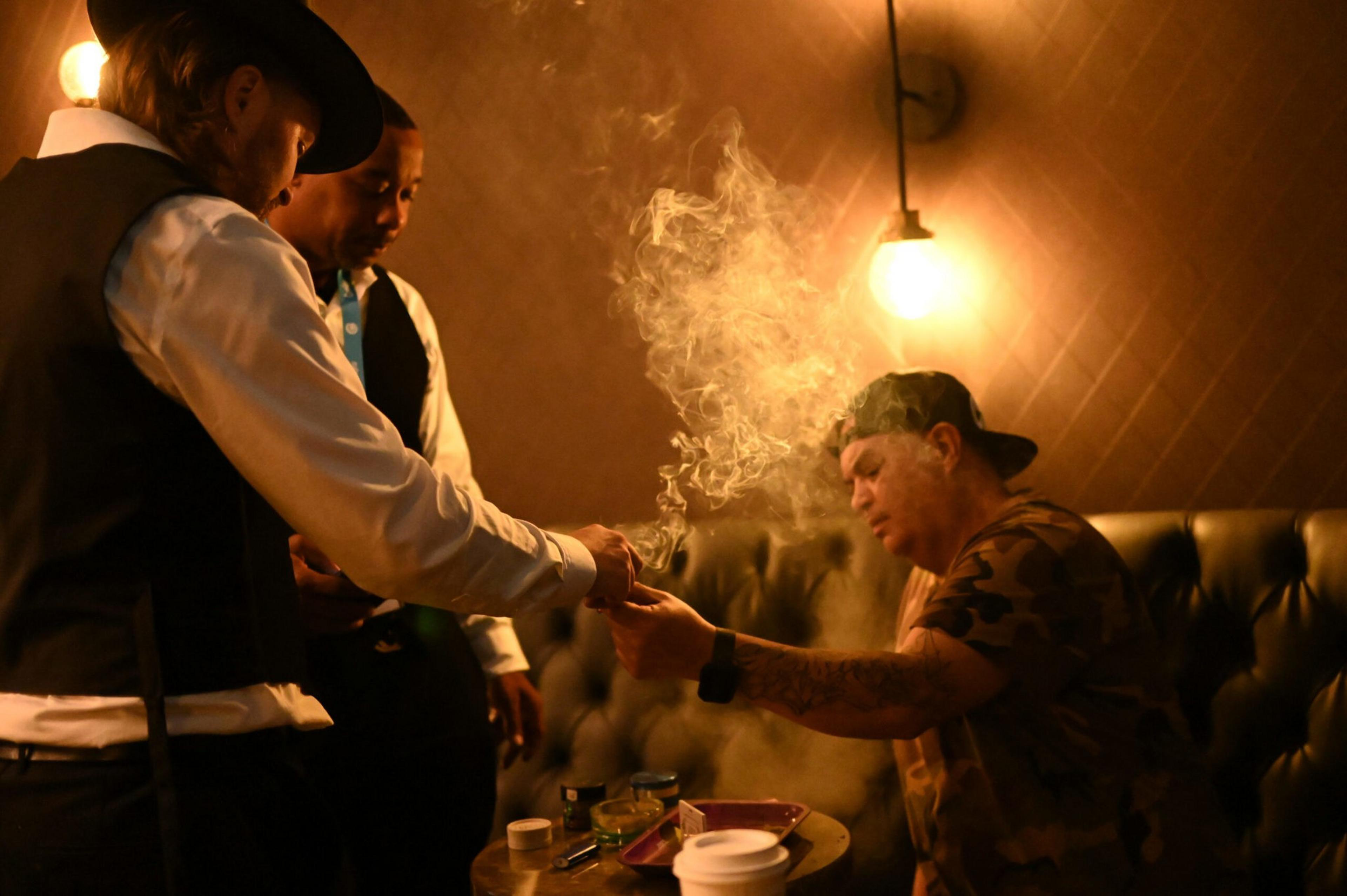 Three men pass a joint around.