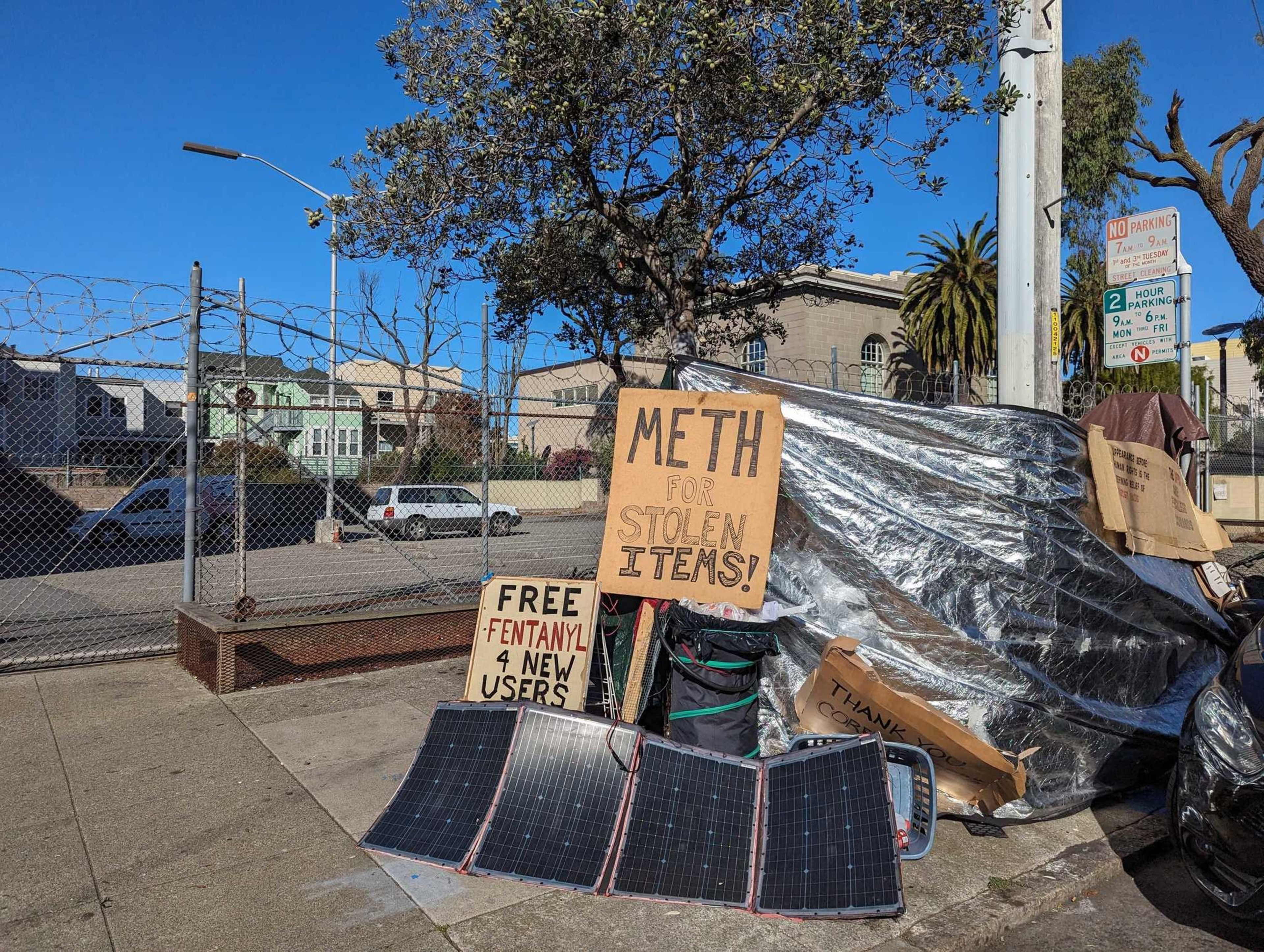 Signs reading &quot;Meth for stolen items&quot; and &quot;free fentanyl for new users&quot; sit atop Joseph Adam Moore's encampment on Ninth Avenue north of Geary Boulevard in San Francisco's Inner Richmond neighborhood.