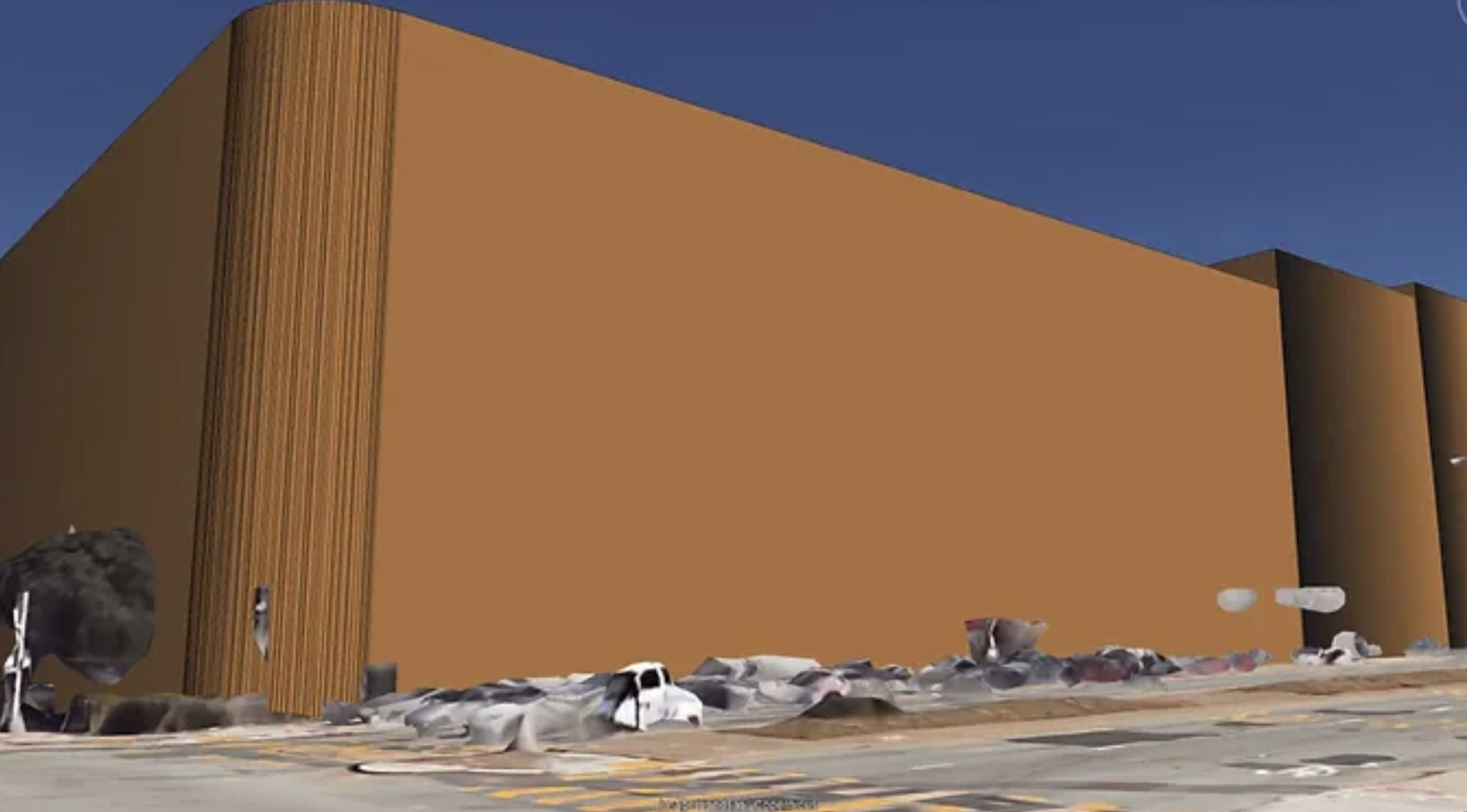 The image shows a large, featureless orange building with a vertical striped texture on one corner. Distorted objects in the foreground resemble cars and debris.