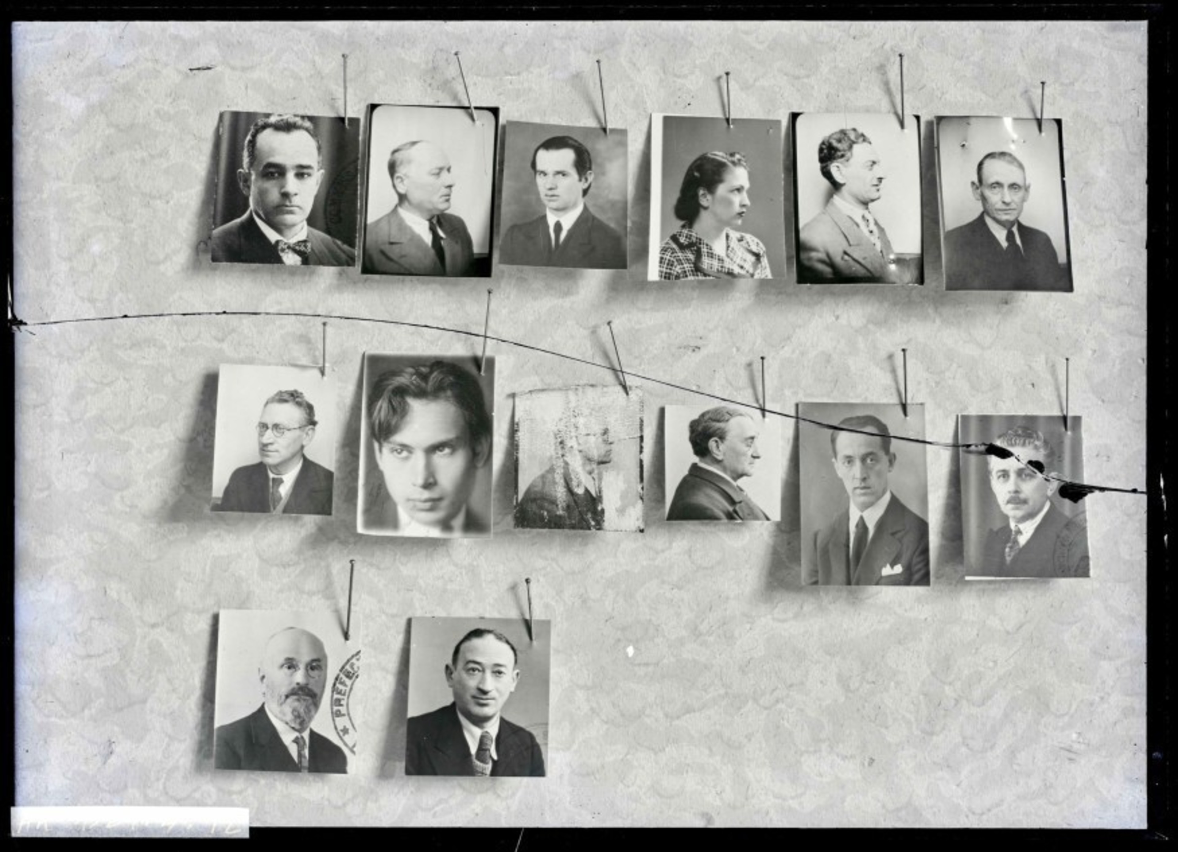 Vintage photos of various people hung on strings against a textured background.