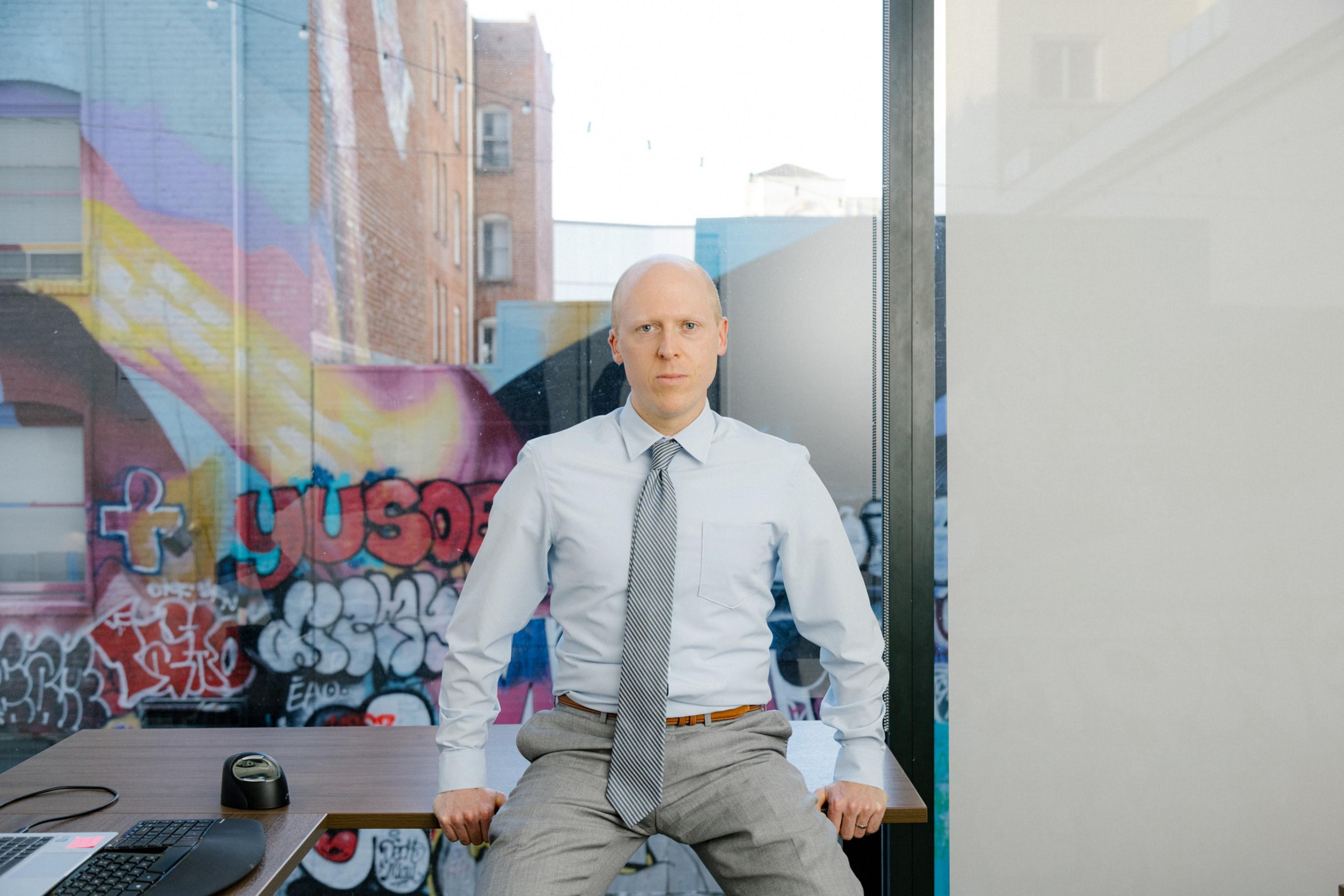 Patrick Ford sits at a desk.