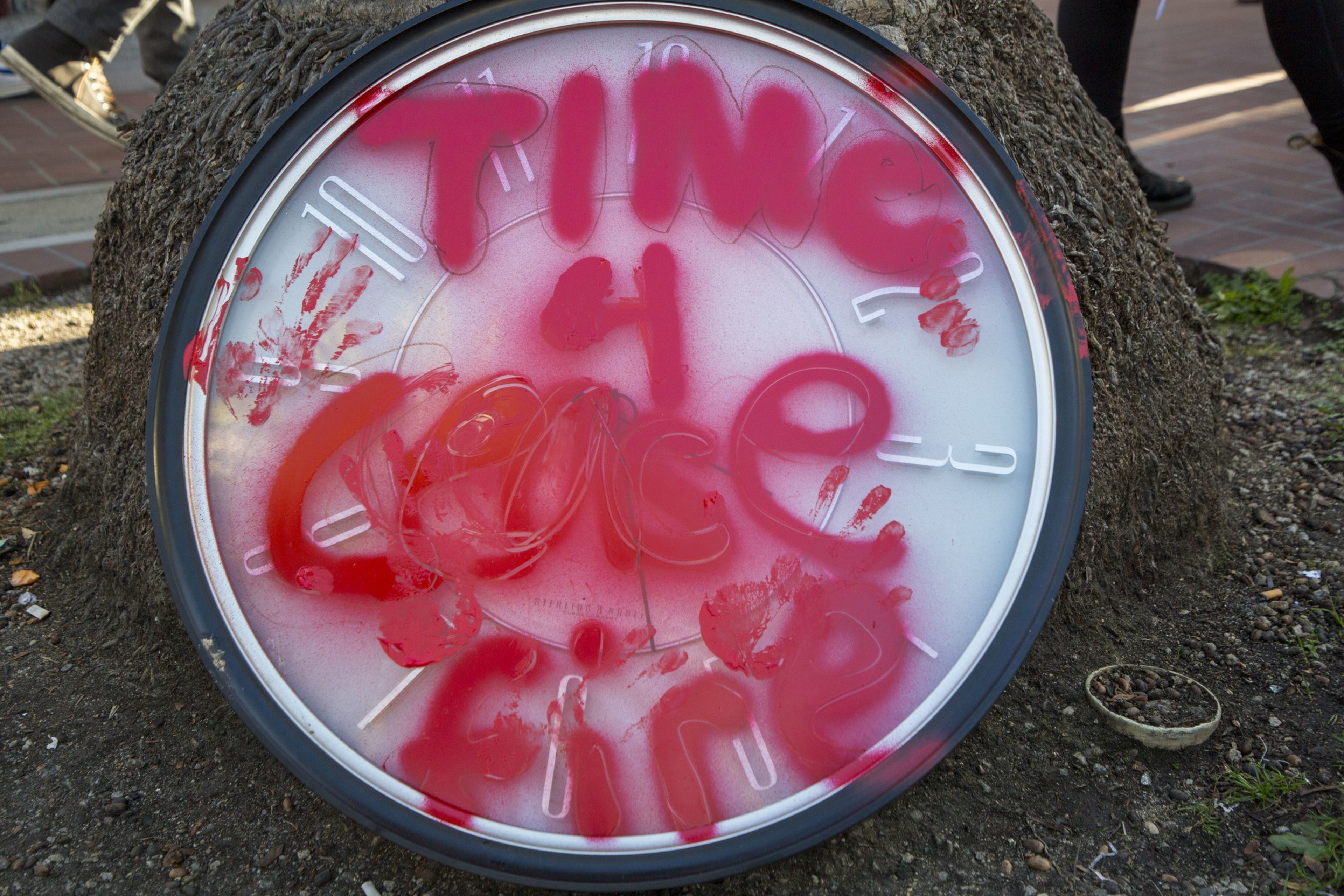 &quot;Time 4 Cease Fire&quot; sprayed on a clock with red paint.