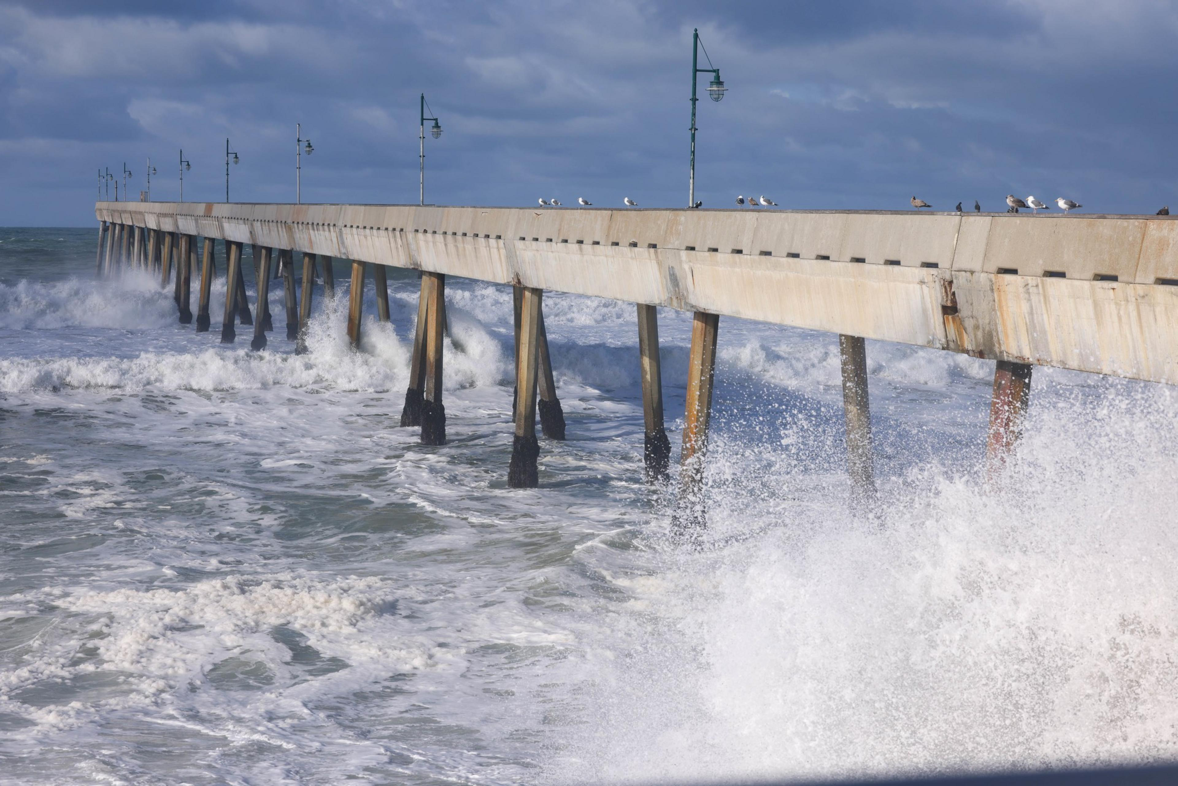 Waves crash along a pier