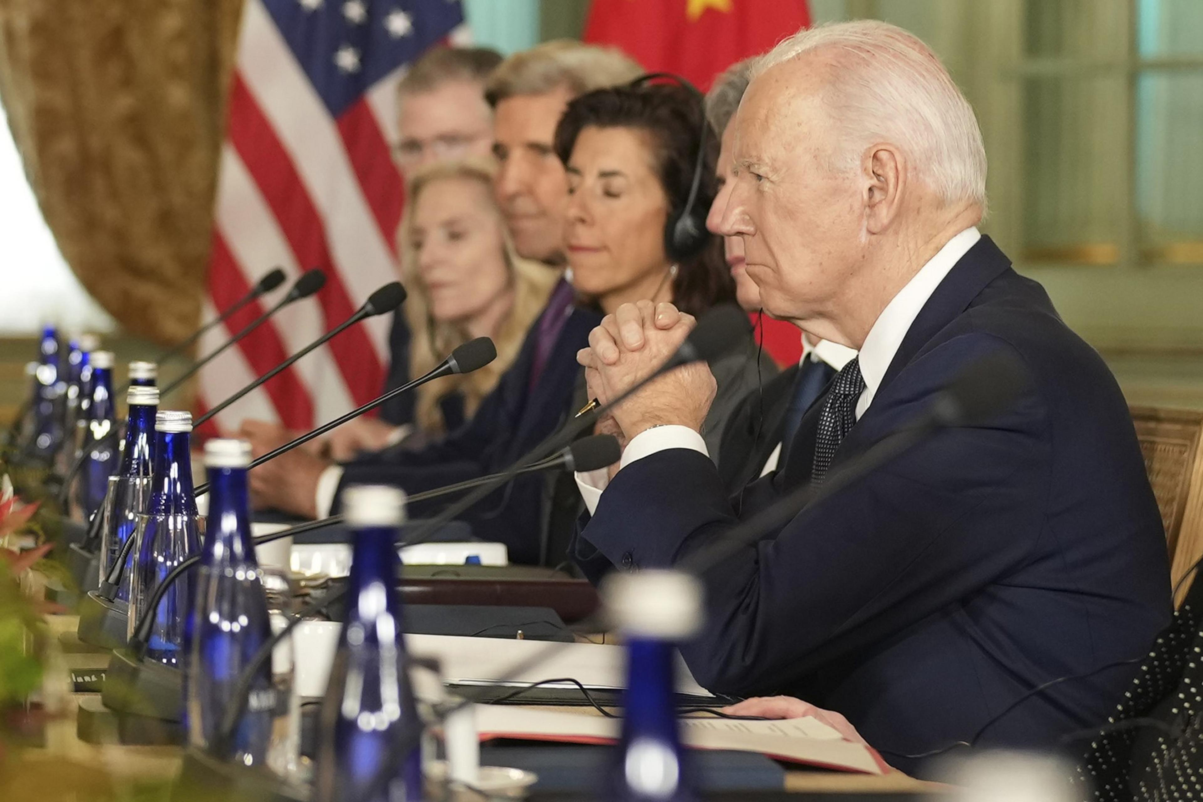 A row of people including U.S. President Joe Biden looks off screen.