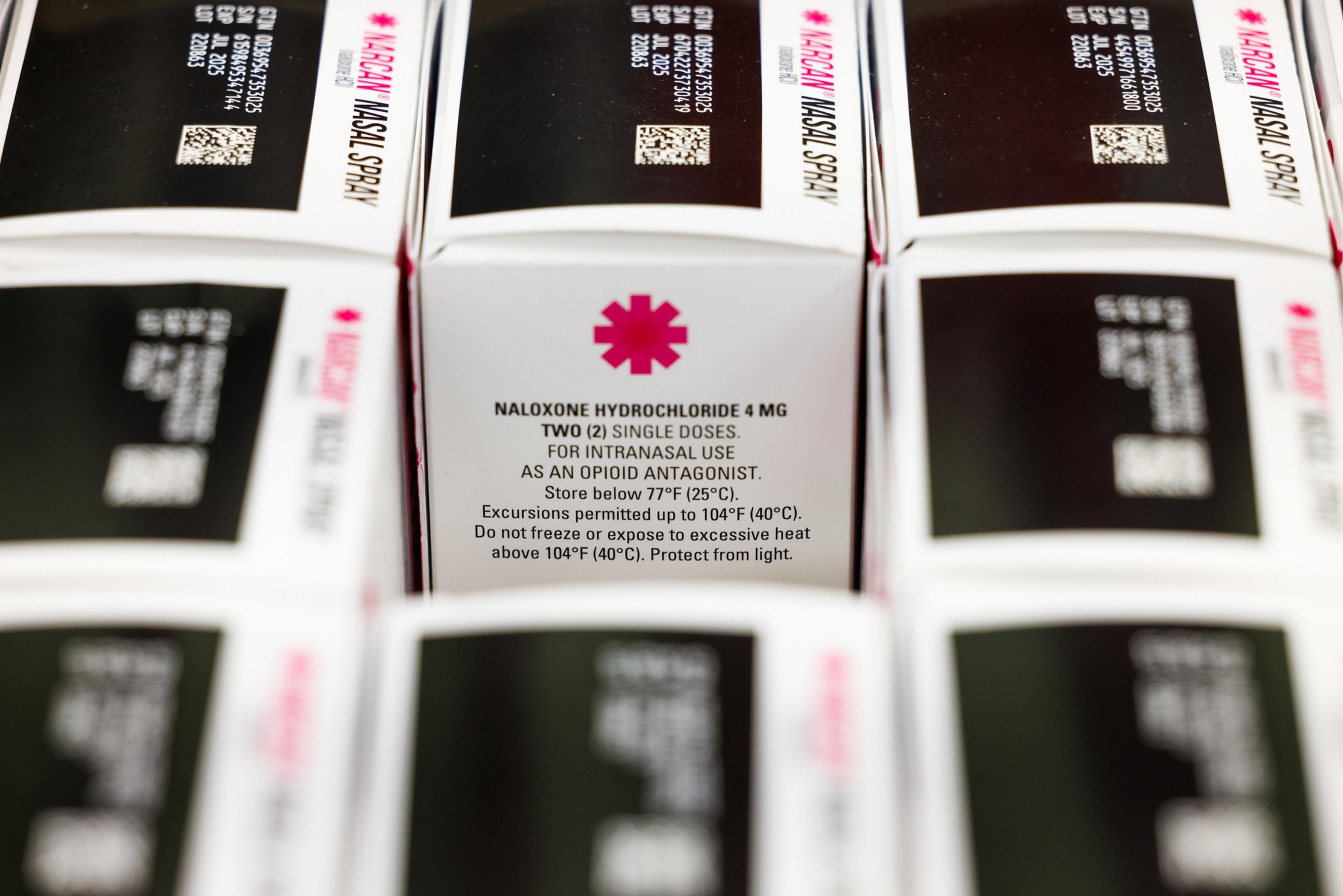Boxes of naloxone hydrochloride nasal spray for intranasal use, showing dosage instructions and storage guidelines to prevent heat and light damage.
