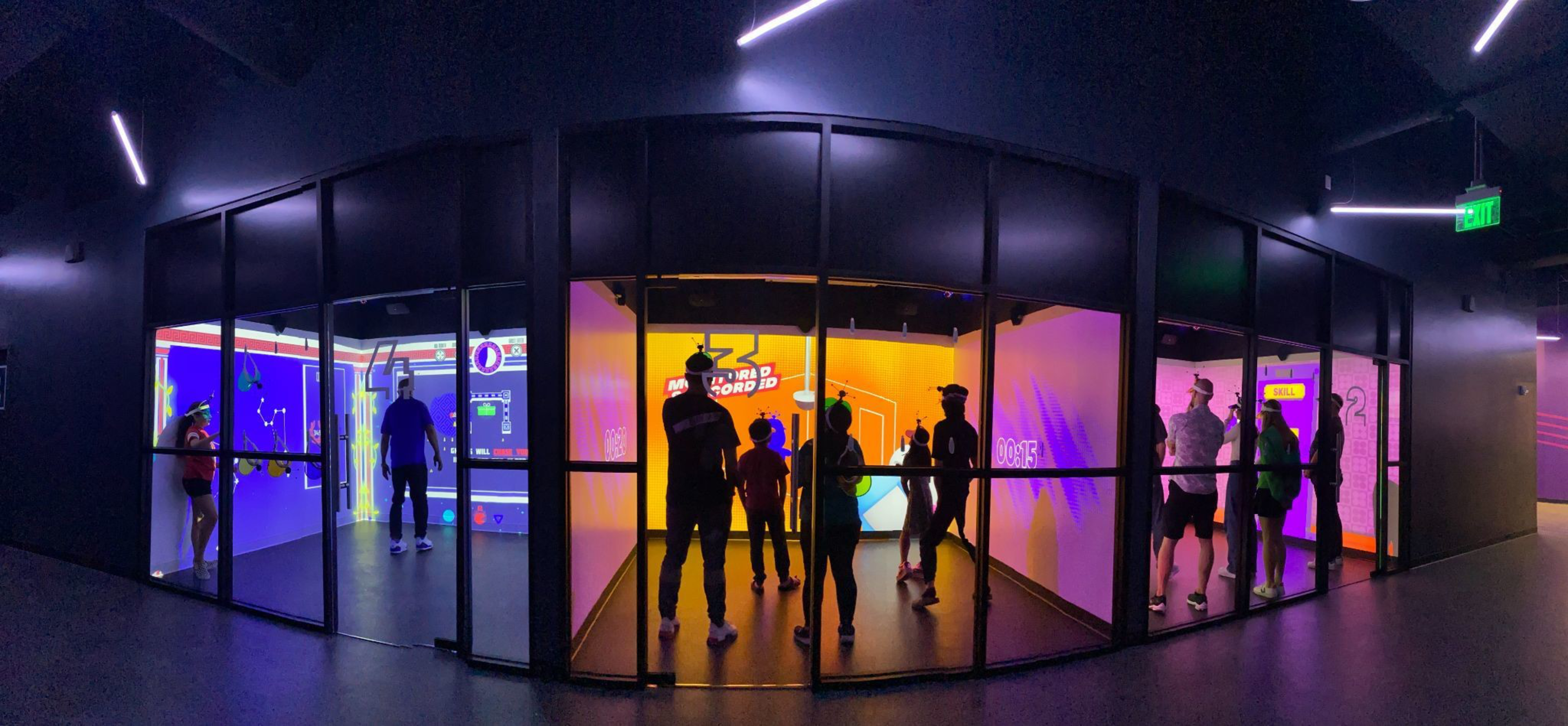 People are silhouetted against a colored backdrop.